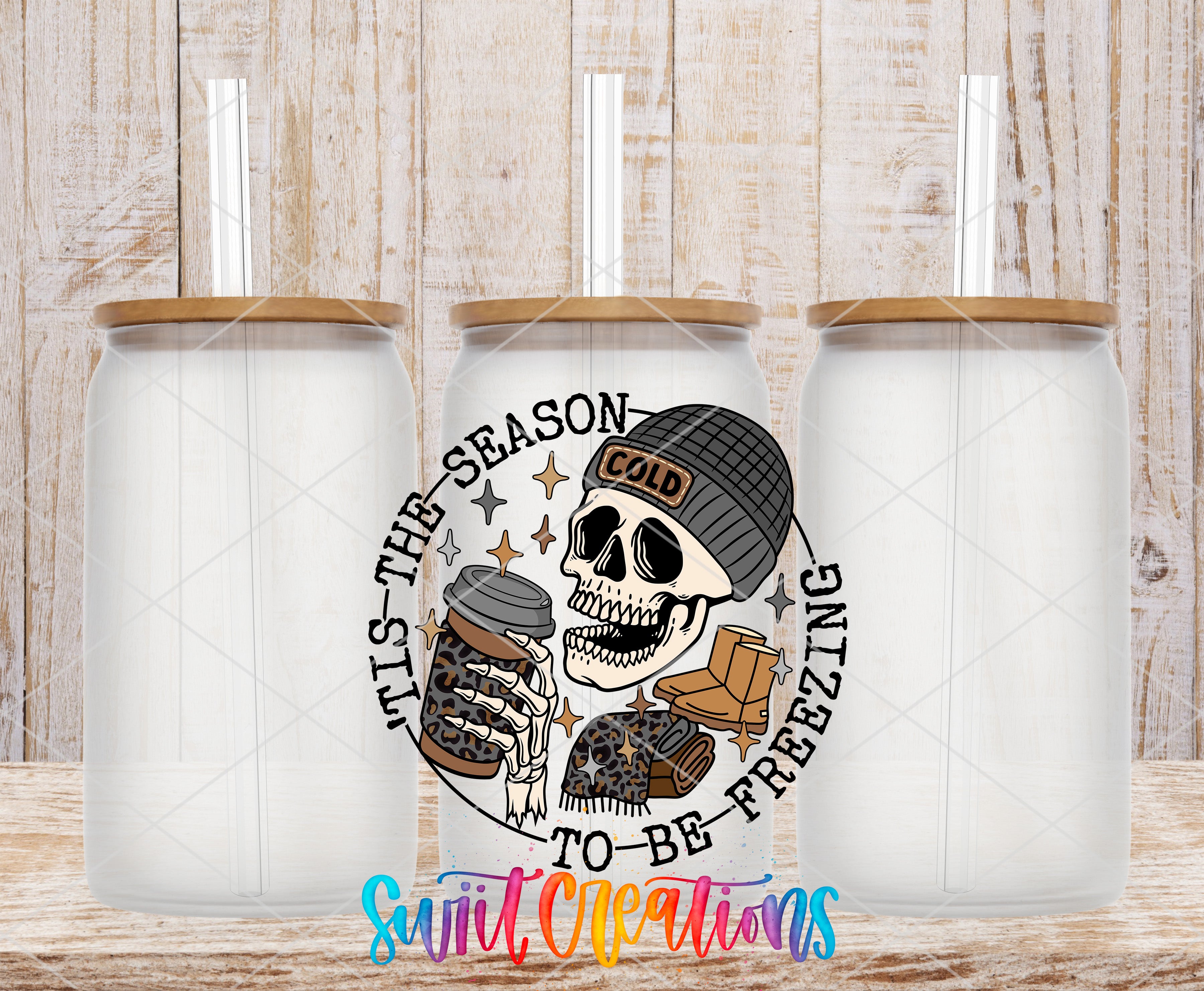 three glass jars with a skull design and text, set against a wooden background.
