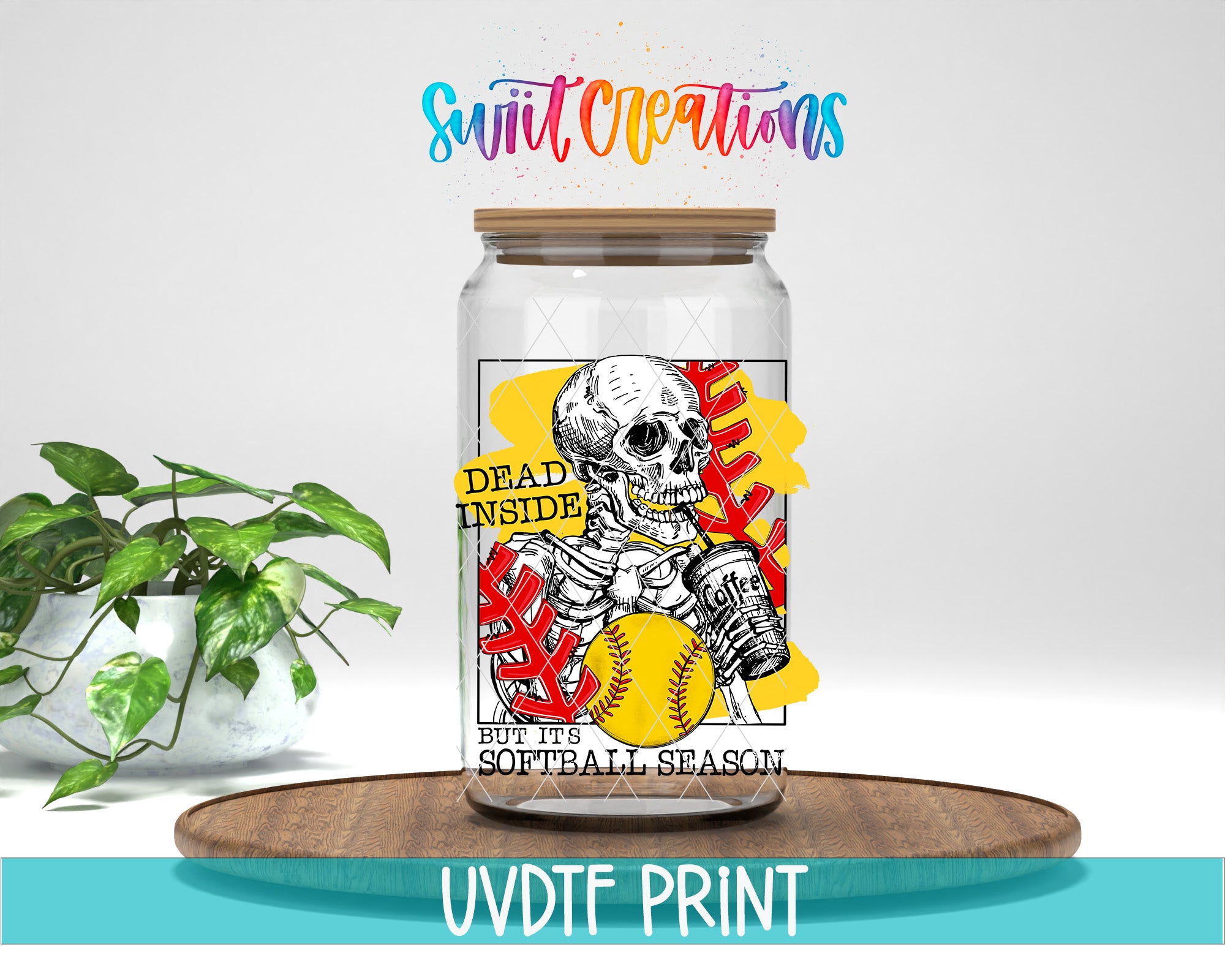 A glass jar with a label featuring a skeleton holding a baseball and the text "Dead inside but its softball season" printed on it. The jar is placed on a wooden surface, and there is a potted plant in the background.