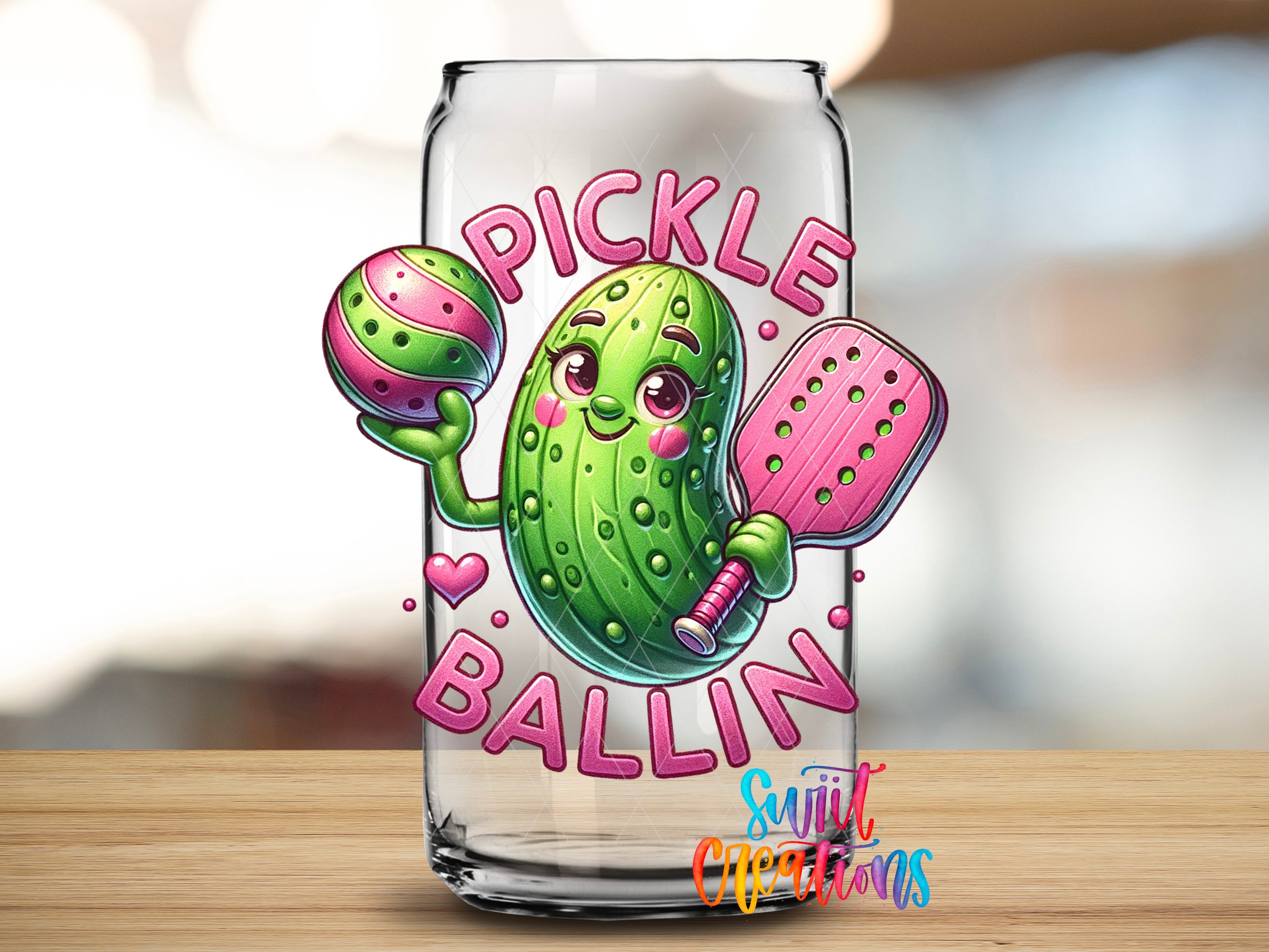 A glass can with a cartoon image of a pickle character holding a tennis racket and a ball, along with the text "PICKLE BALLIN" and a heart symbol.
