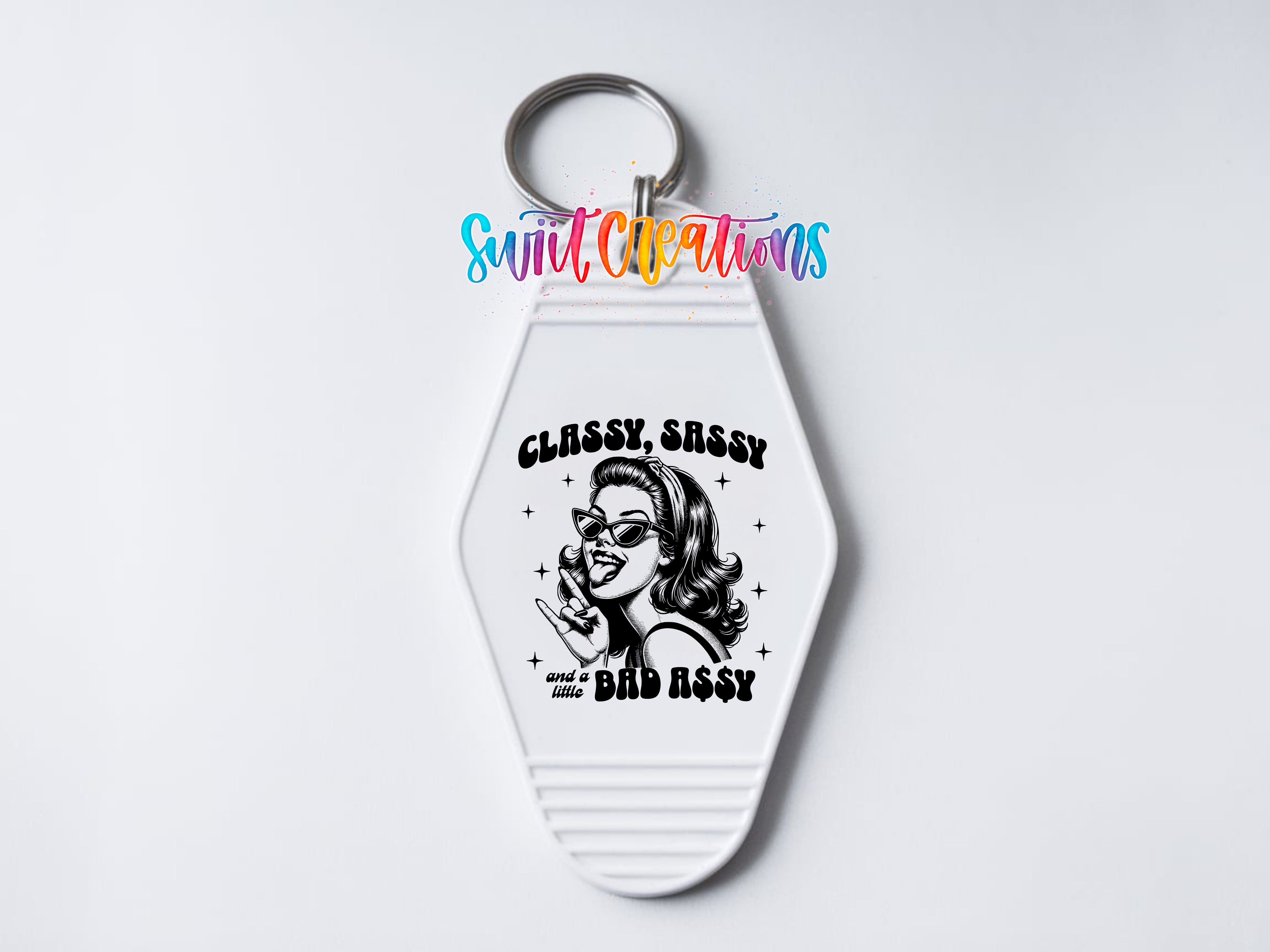 A keychain with a graphic design featuring a woman with sunglasses and the text "CLASSY, SASSY AND A BAD ASSY" printed on it.