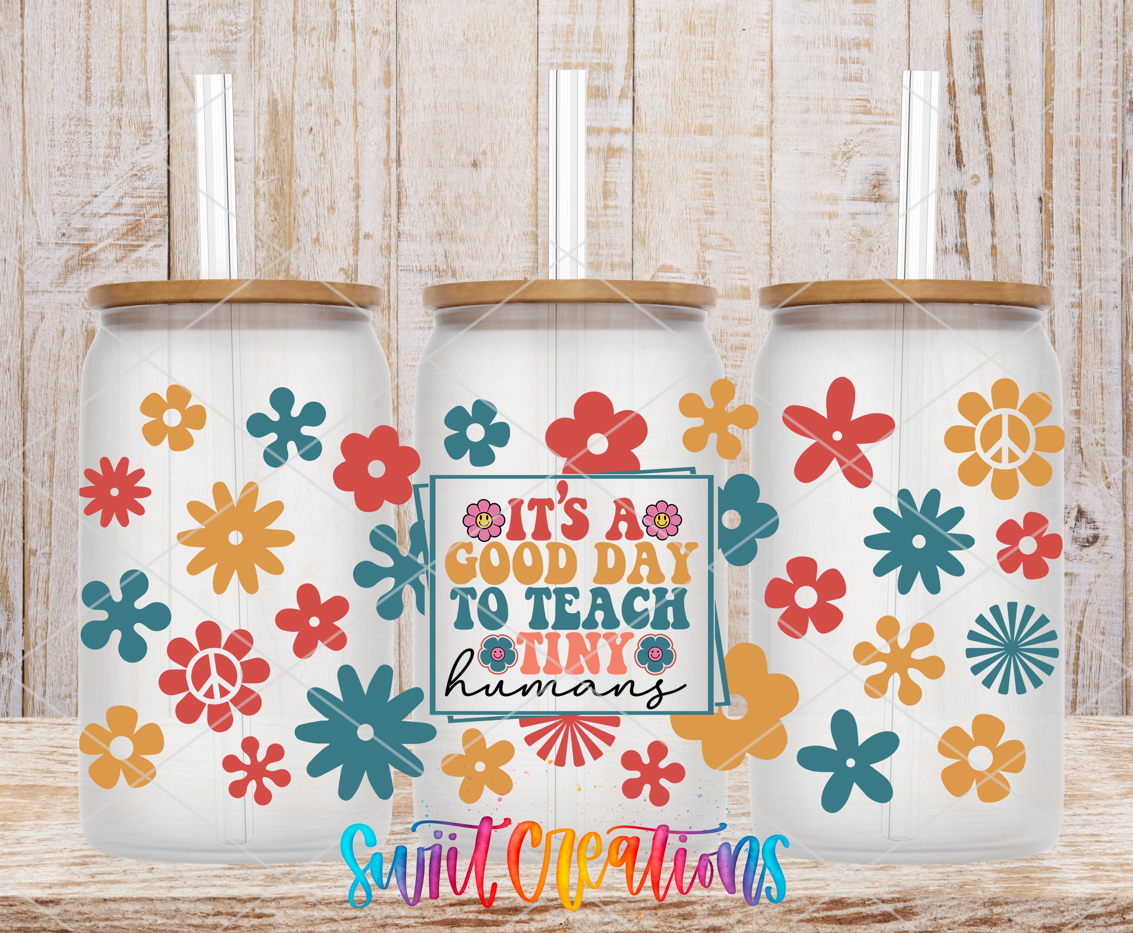 three glass tumblers with colorful flower designs and straws. The tumblers are arranged in a row, with the middle one having a sign that reads "It's a good day to teach tiny humans".