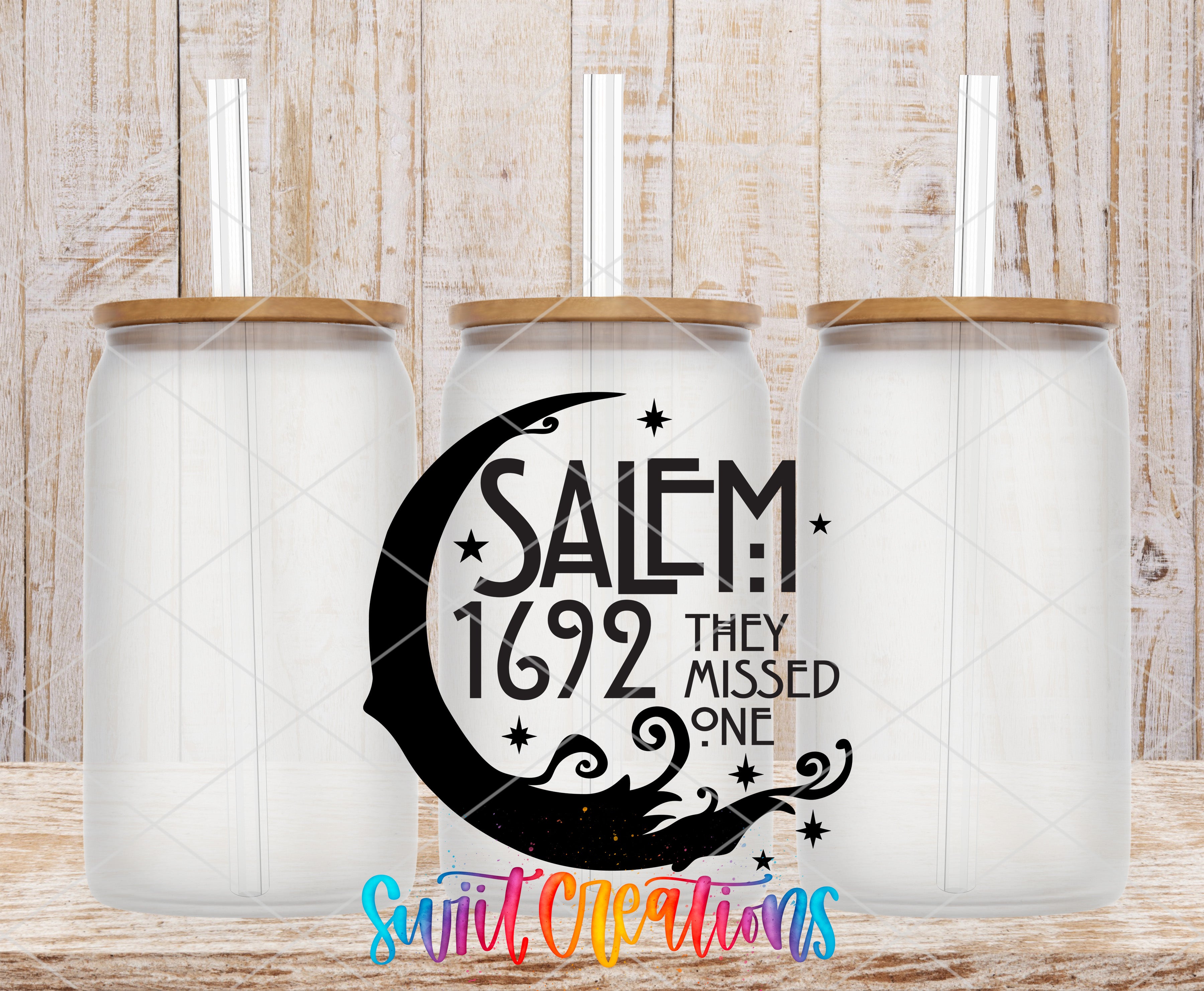 three clear glass jars with wooden lids, each with a straw sticking out of the top. The jars are arranged in a row, and there is a text design in the center of the image that reads "SALEM 1692 THEY MISSED ONE".