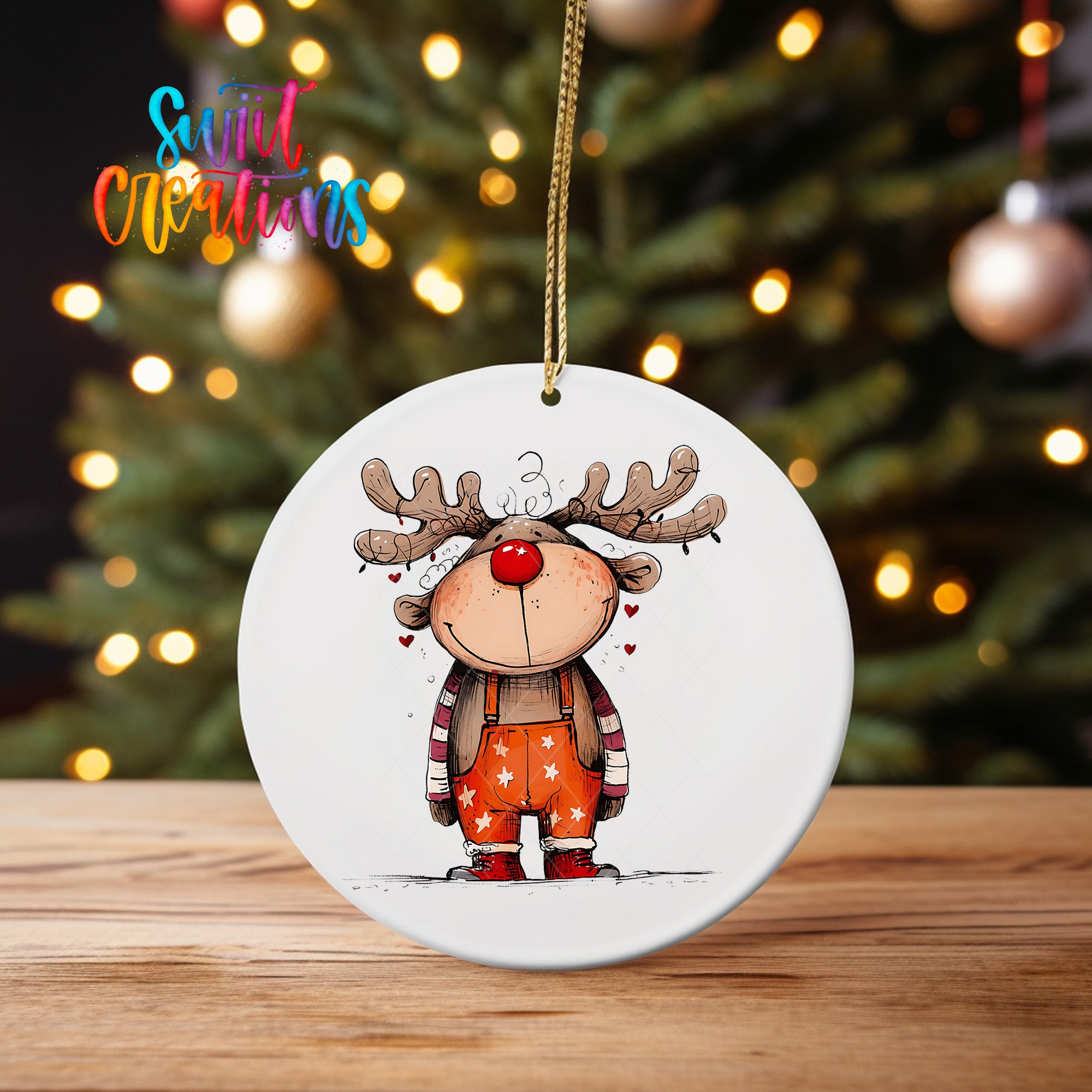 A white ornament featuring a cartoon reindeer with antlers and a red nose, hanging on a string.