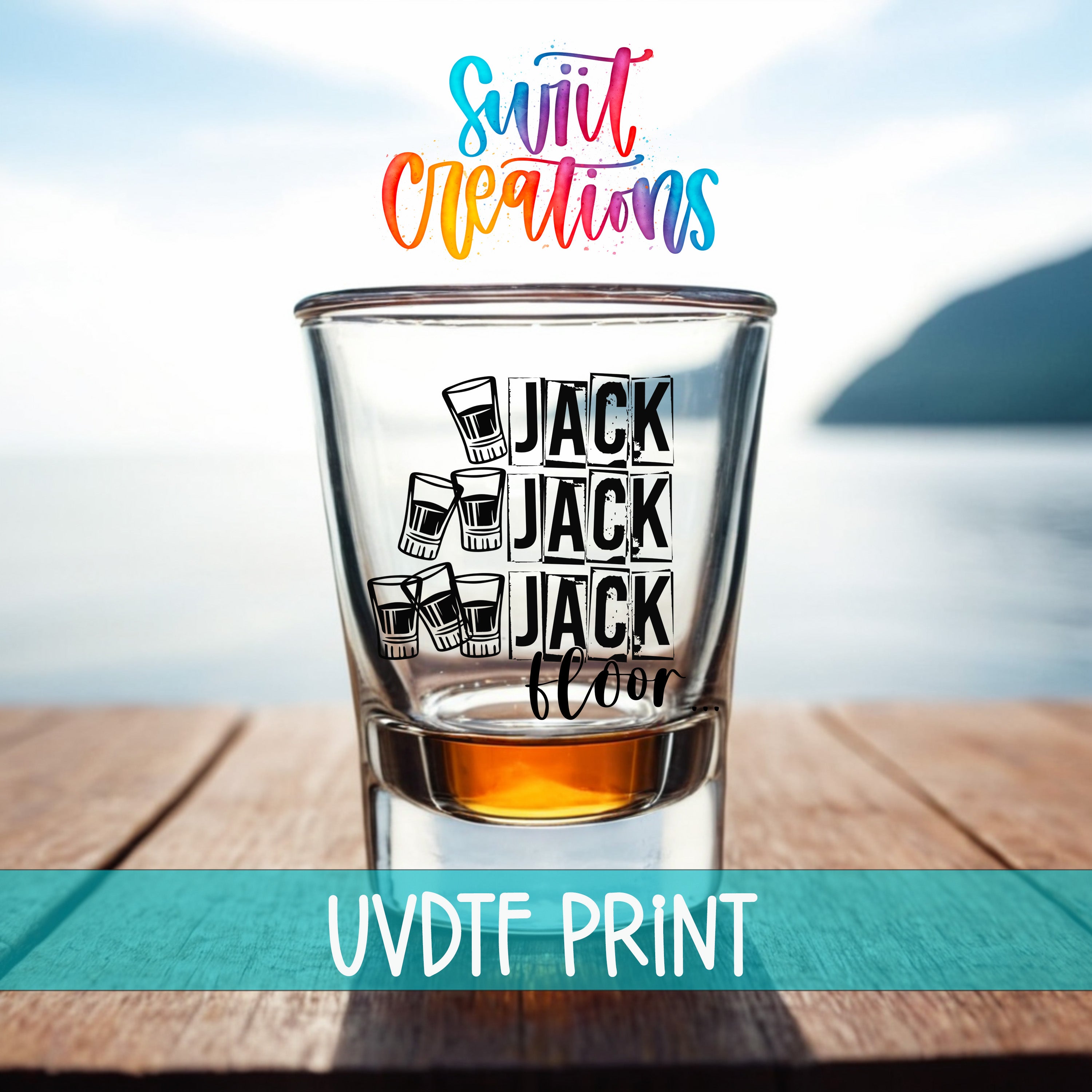 A shot glass with the text "JACK JACK FLOOR" printed on it, placed on a wooden surface with a body of water in the background.