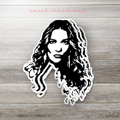 Stack of Alexis Portrait glossy stickers on a gray wood table