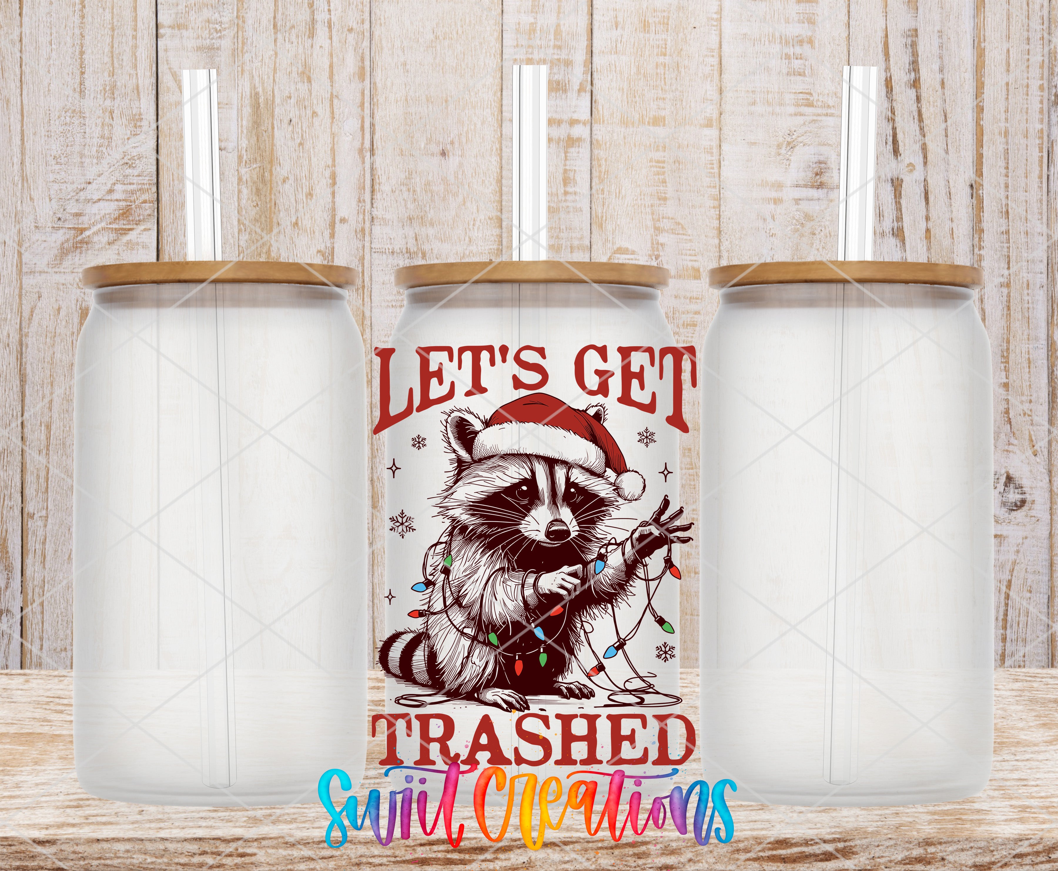 three clear glass jars with lids, each containing a straw. The jars are arranged in a row, with the middle jar having a colorful design featuring a raccoon wearing a Santa hat and holding Christmas lights. The text on the jar reads "Let's Get Trashed Sweet Christmas".
