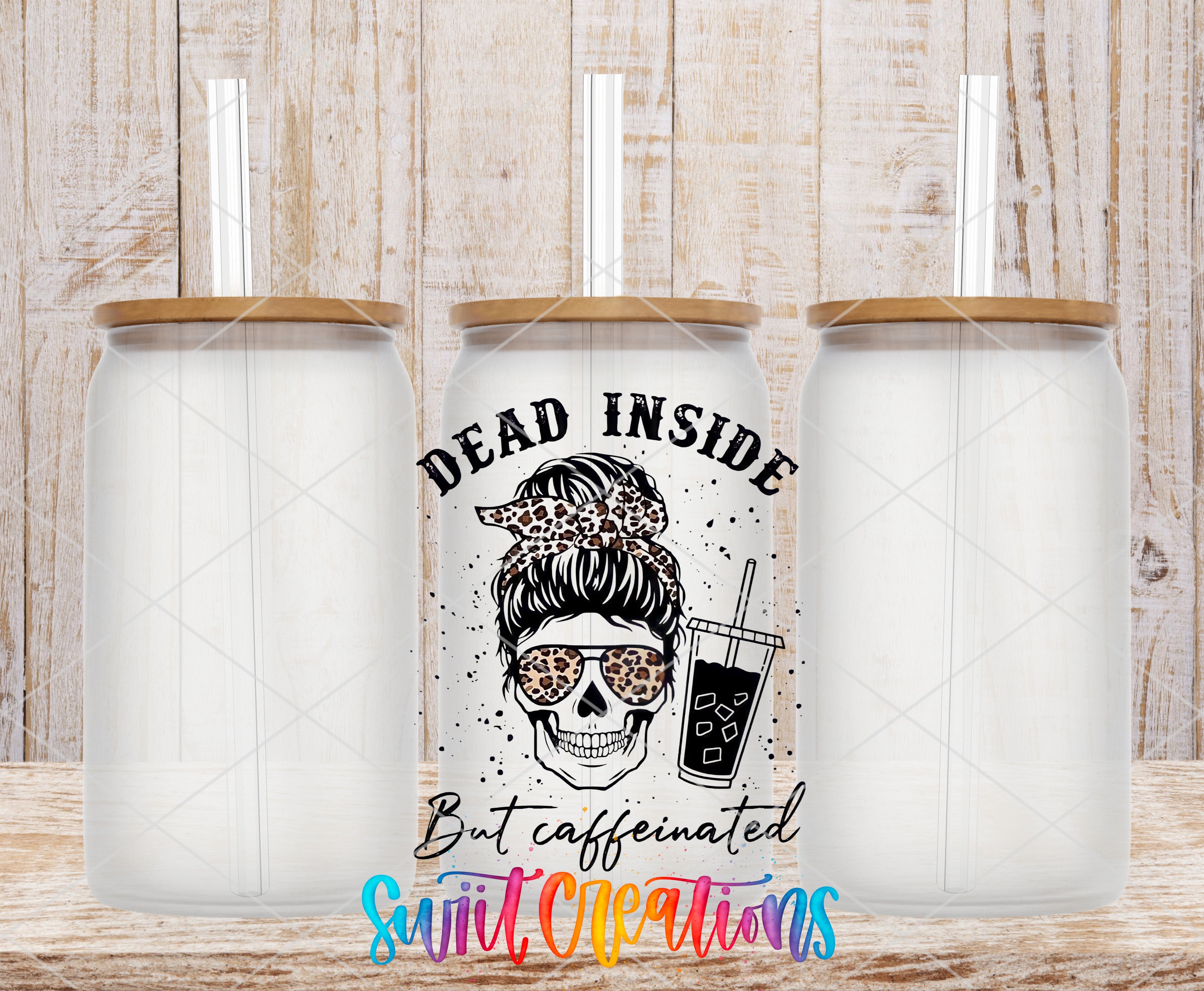 three clear glass tumblers with straws, each with a unique design and text. The central tumbler has a skull design and the text "Dead Inside But caffeinated" written on it.