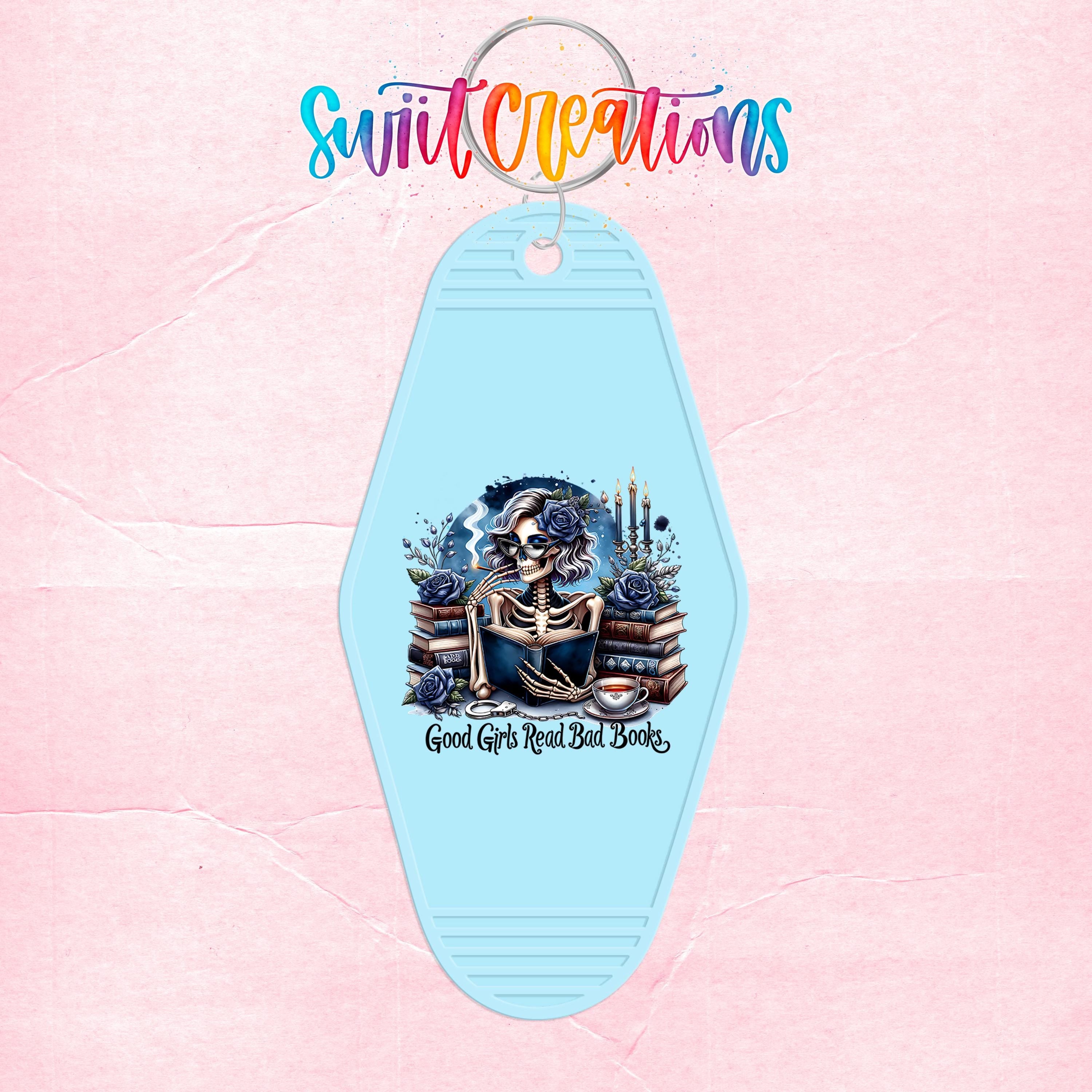 A keychain with a skull design and the text "Good Girls Read Bad Books" printed on it.