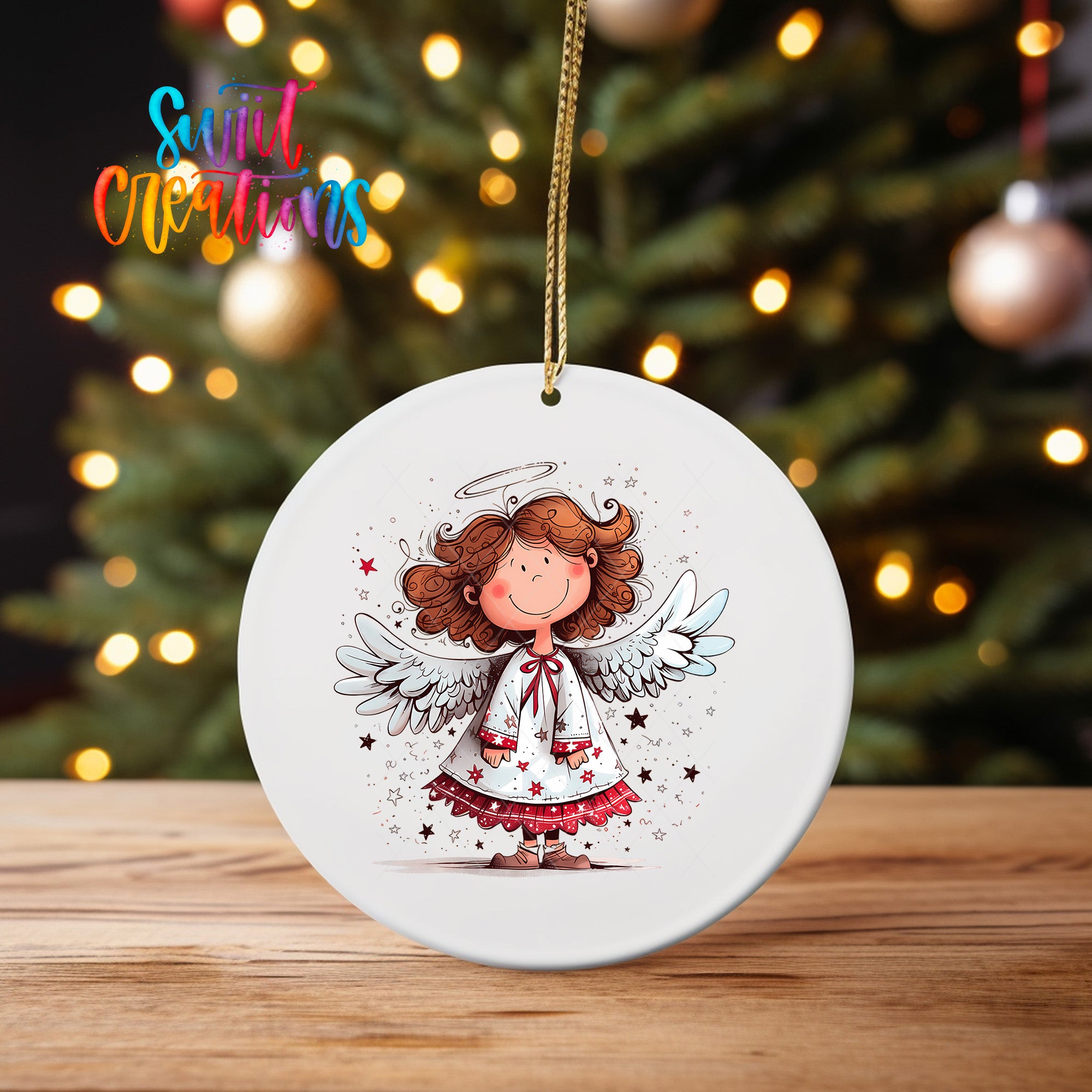 A white ceramic ornament featuring a cartoon illustration of an angel with curly hair, wings, and a halo, set against a blurred background of Christmas lights.