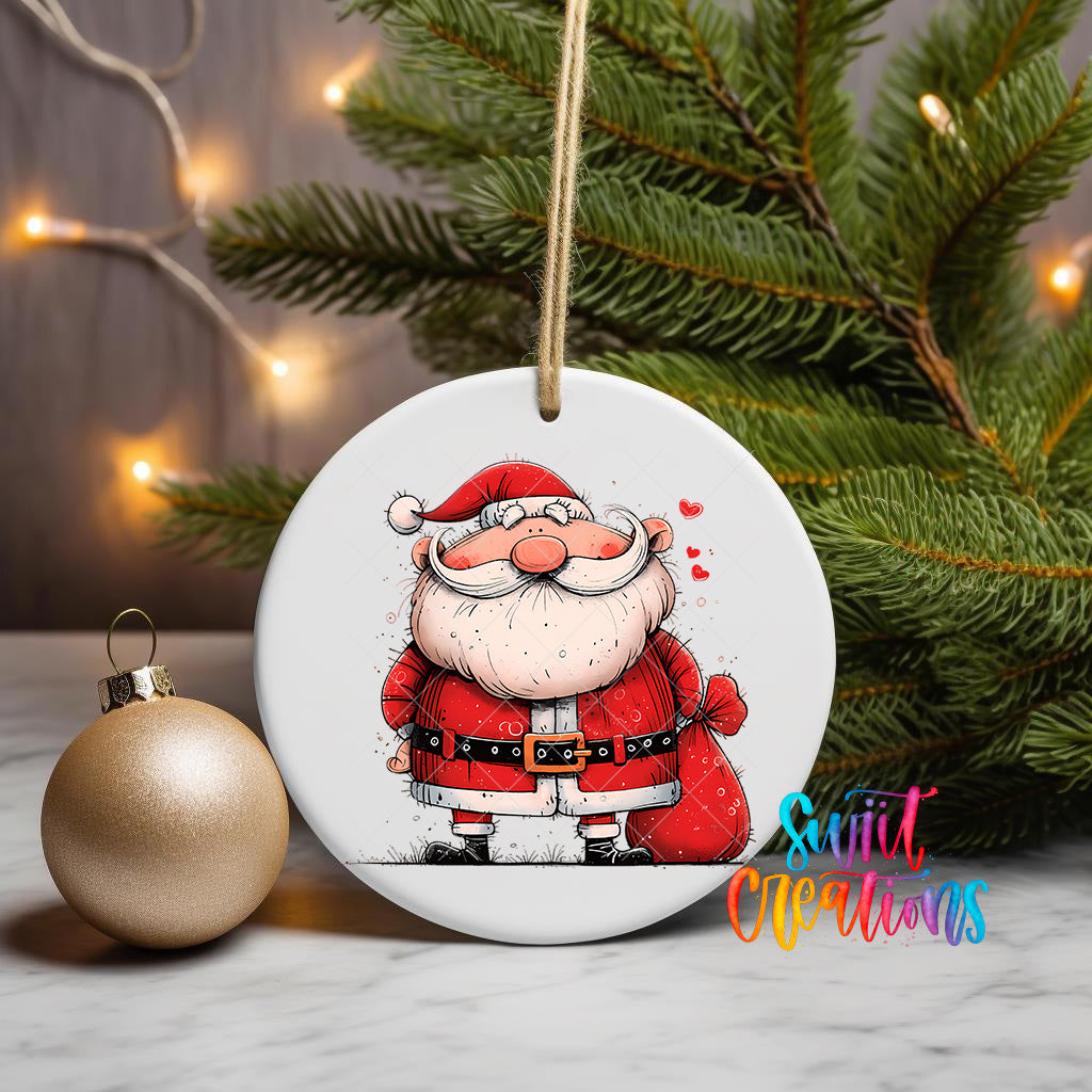 A white ceramic ornament featuring a cartoon Santa Claus figure is displayed on a table, with a gold ornament and a Christmas tree in the background.