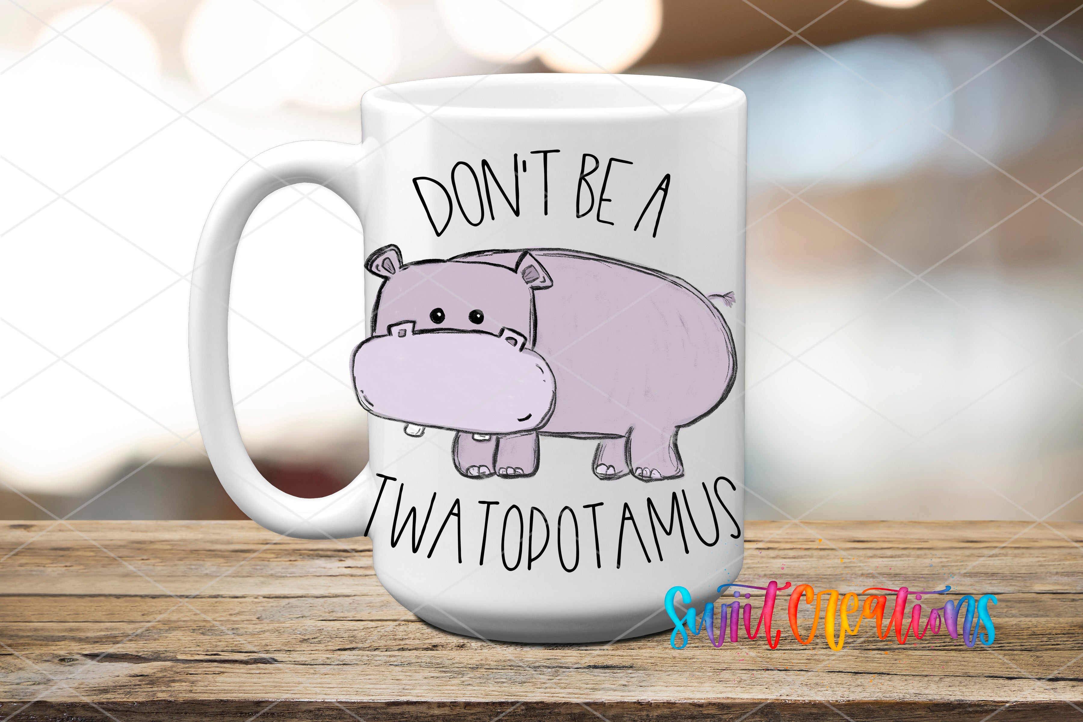 A white mug with a cartoon image of a hippopotamus and the text "DON'T BE A TWATODOTAMUS" printed on it.