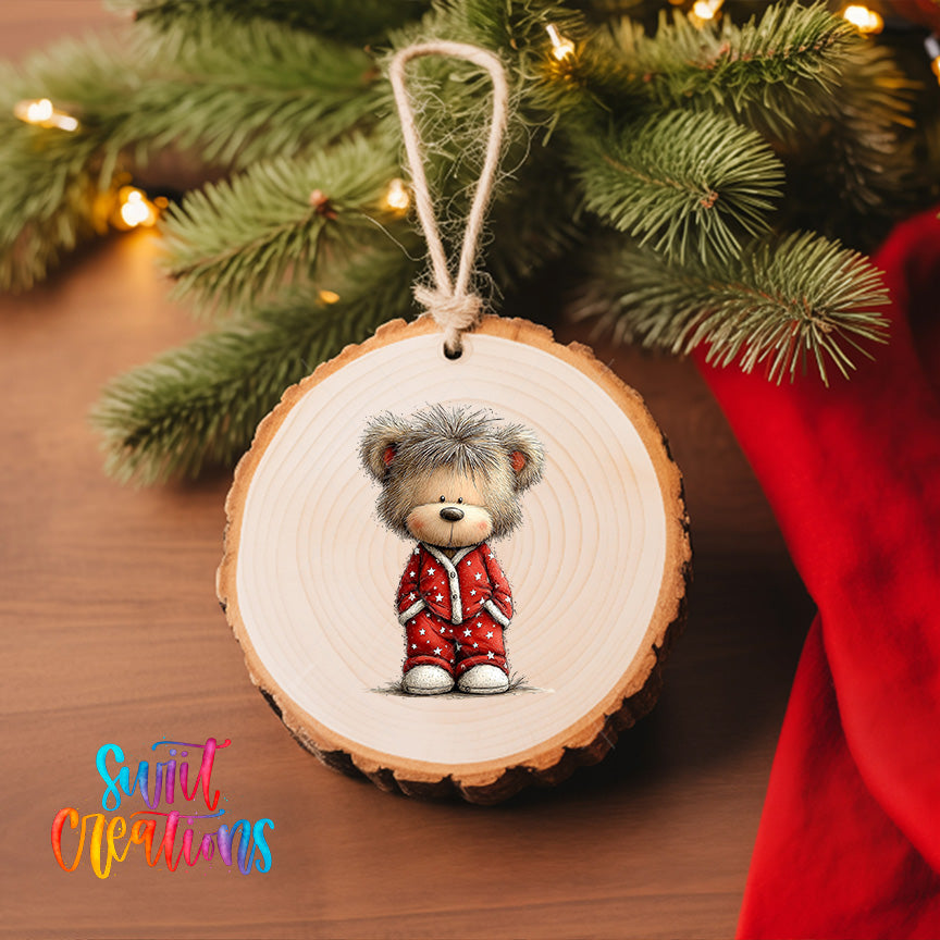 A wooden ornament featuring a teddy bear wearing a red outfit, hanging on a Christmas tree.