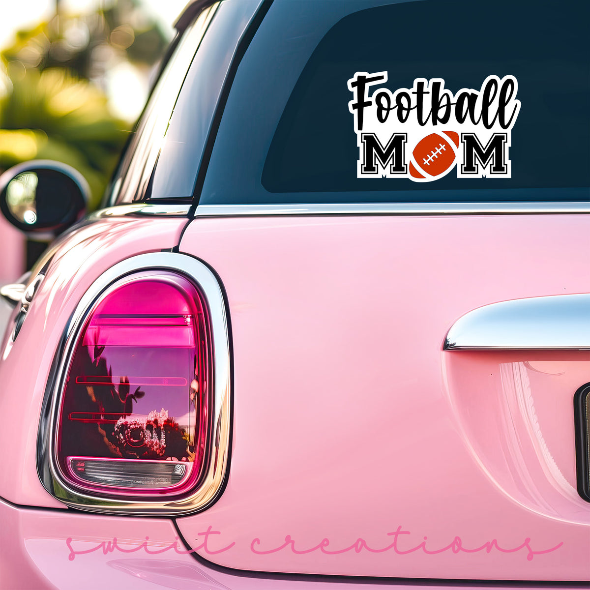 Football Mom sticker on the back window of a pink car