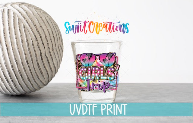 a ball of yarn next to a shot glass