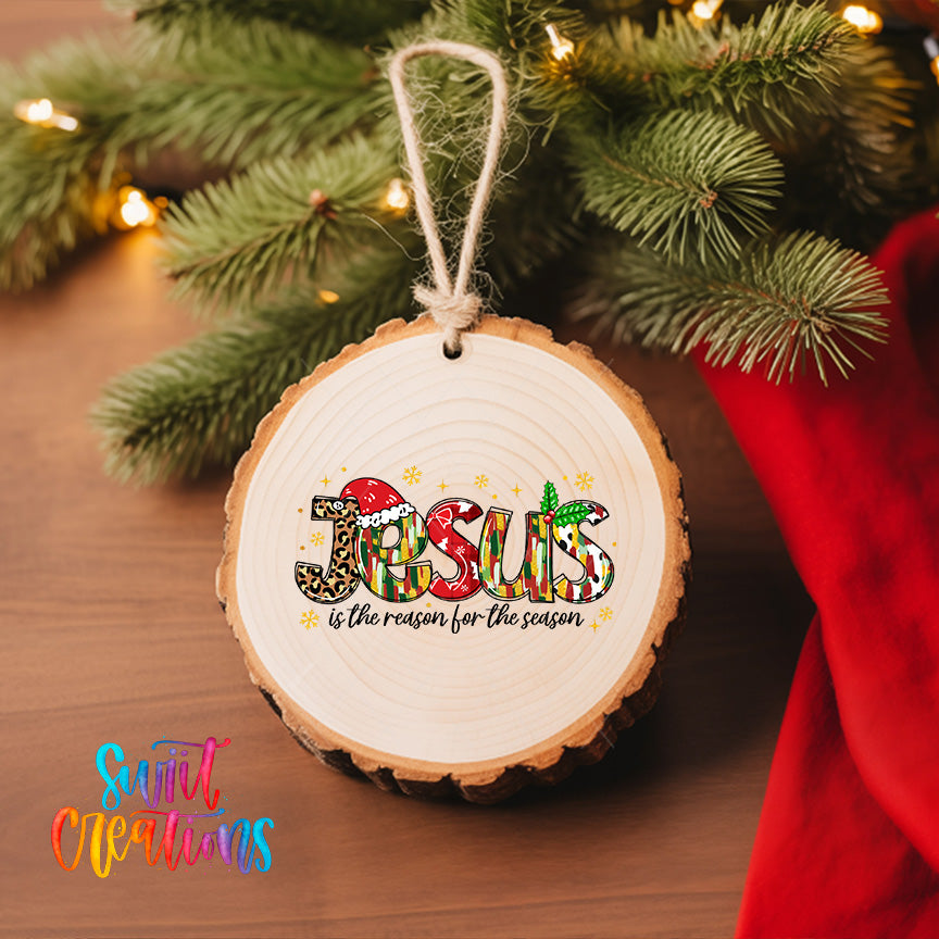 A wooden ornament with the word "JESUS" written on it, hanging on a Christmas tree.
