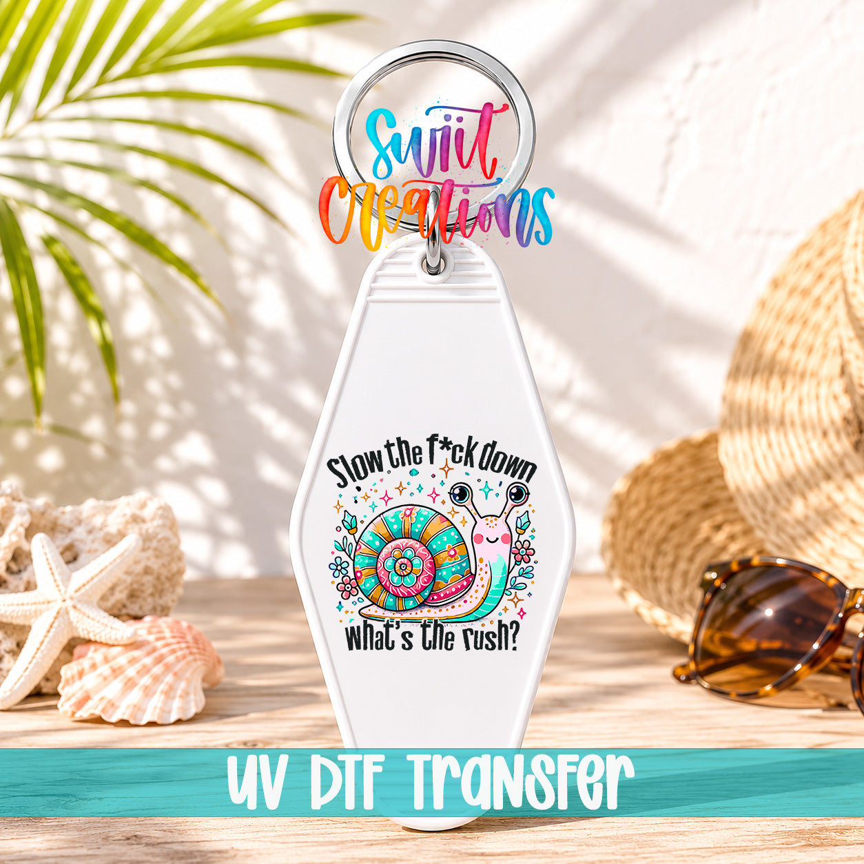 A keychain with a colorful design featuring a snail and the text "Slow the fuck down what's the rush?"