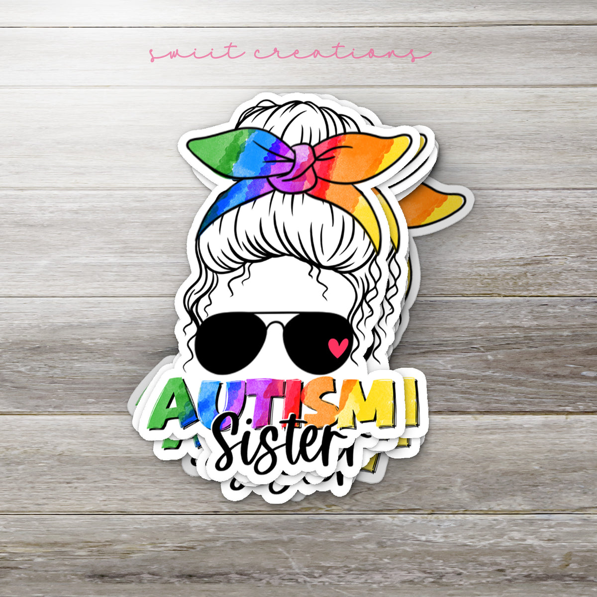 Stack of Autism Sister glossy stickers on a gray wood table