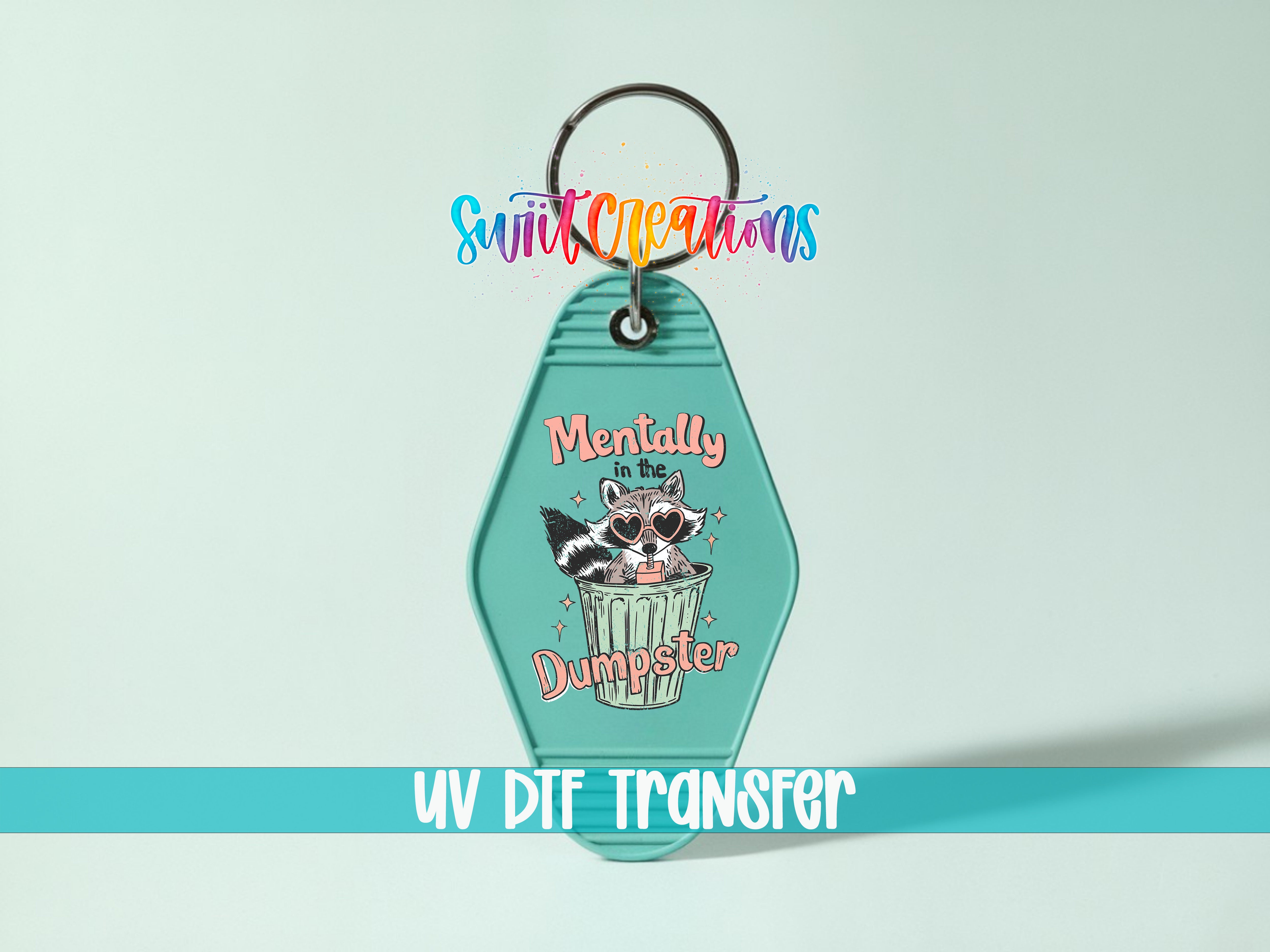 A keychain with a raccoon in a trash can and the text "Mentally in the Dumpster" printed on it.