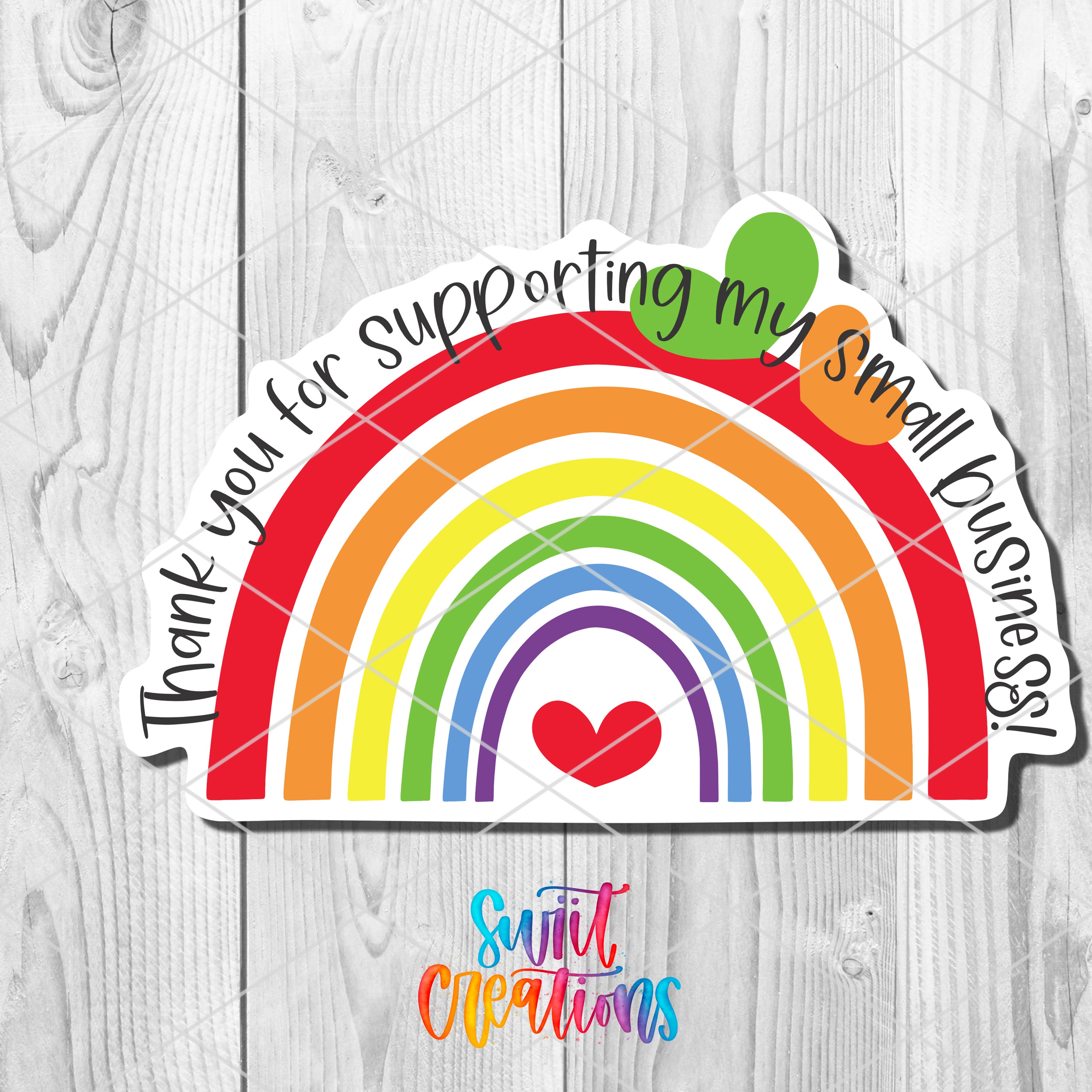 a rainbow sticker on a wooden surface