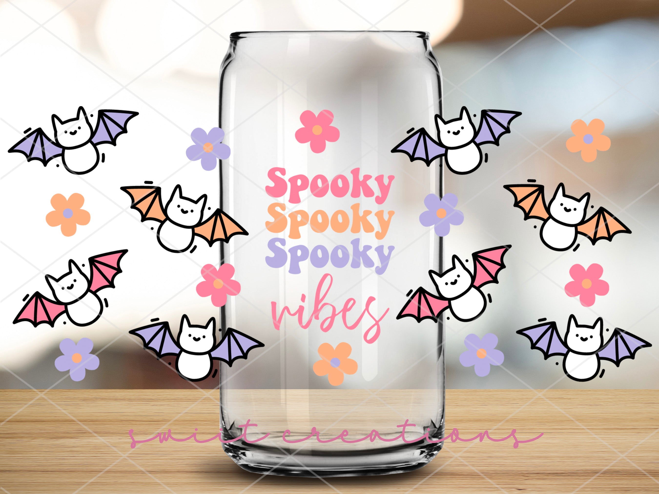 a glass jar with a picture of a bat and flowers on it