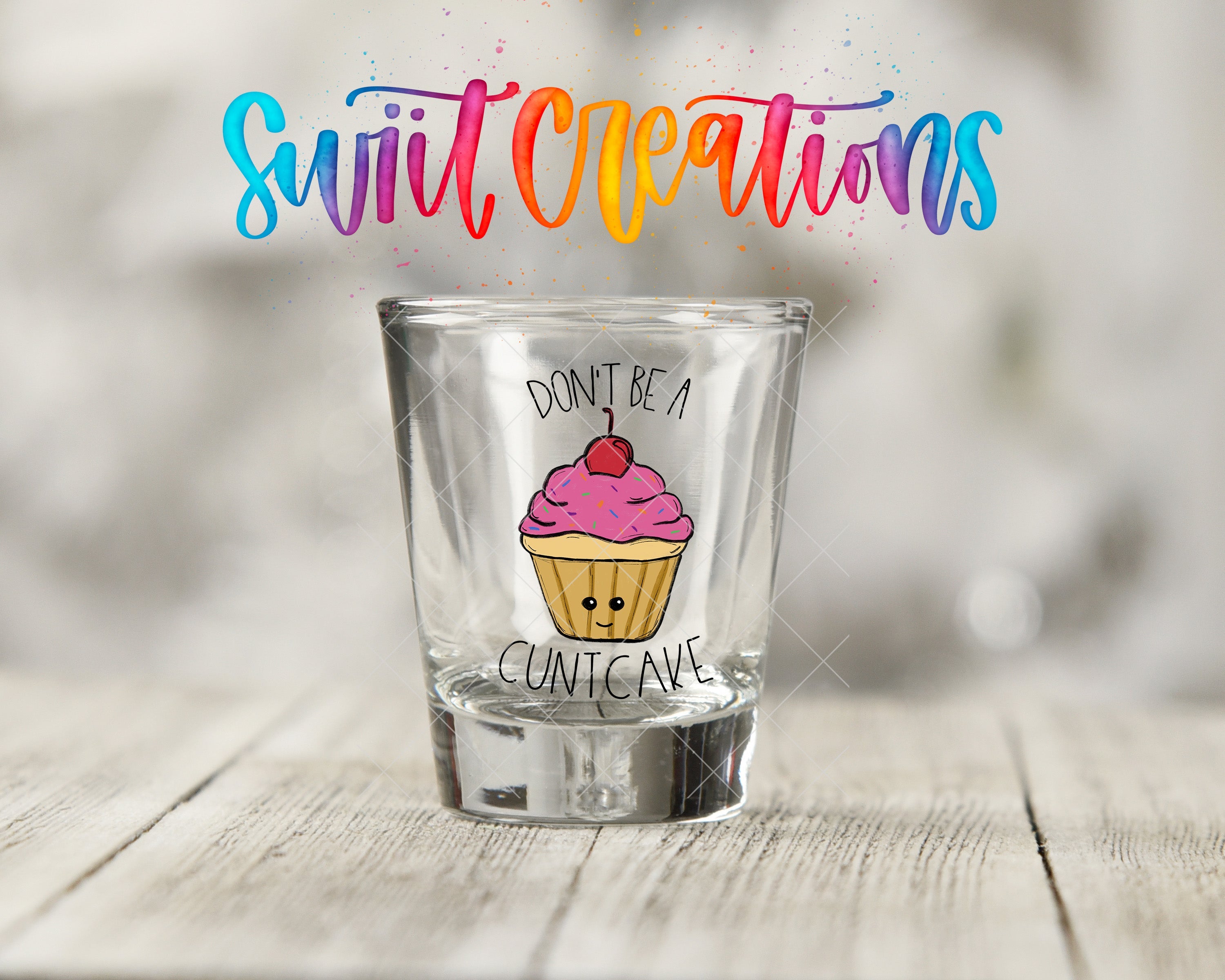 a shot glass with a cupcake painted on it
