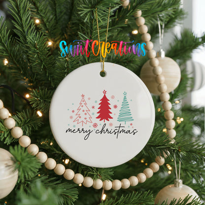 A white ceramic ornament with a festive design hangs on a Christmas tree, surrounded by colorful beads and lights.
