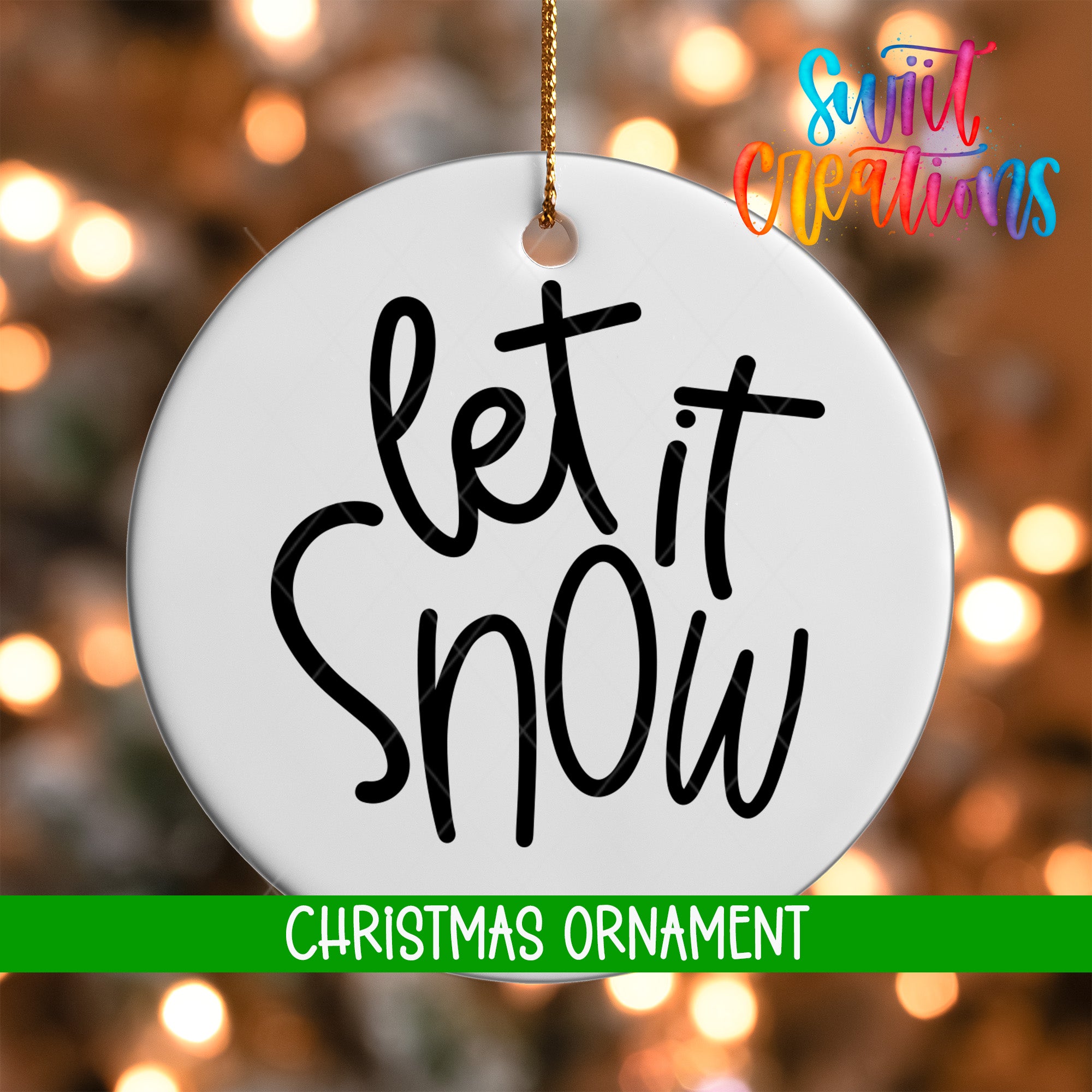 A white Christmas ornament with the text "let it snow" written on it, hanging against a background of colorful, blurred lights.