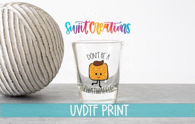 a ball of yarn next to a shot glass