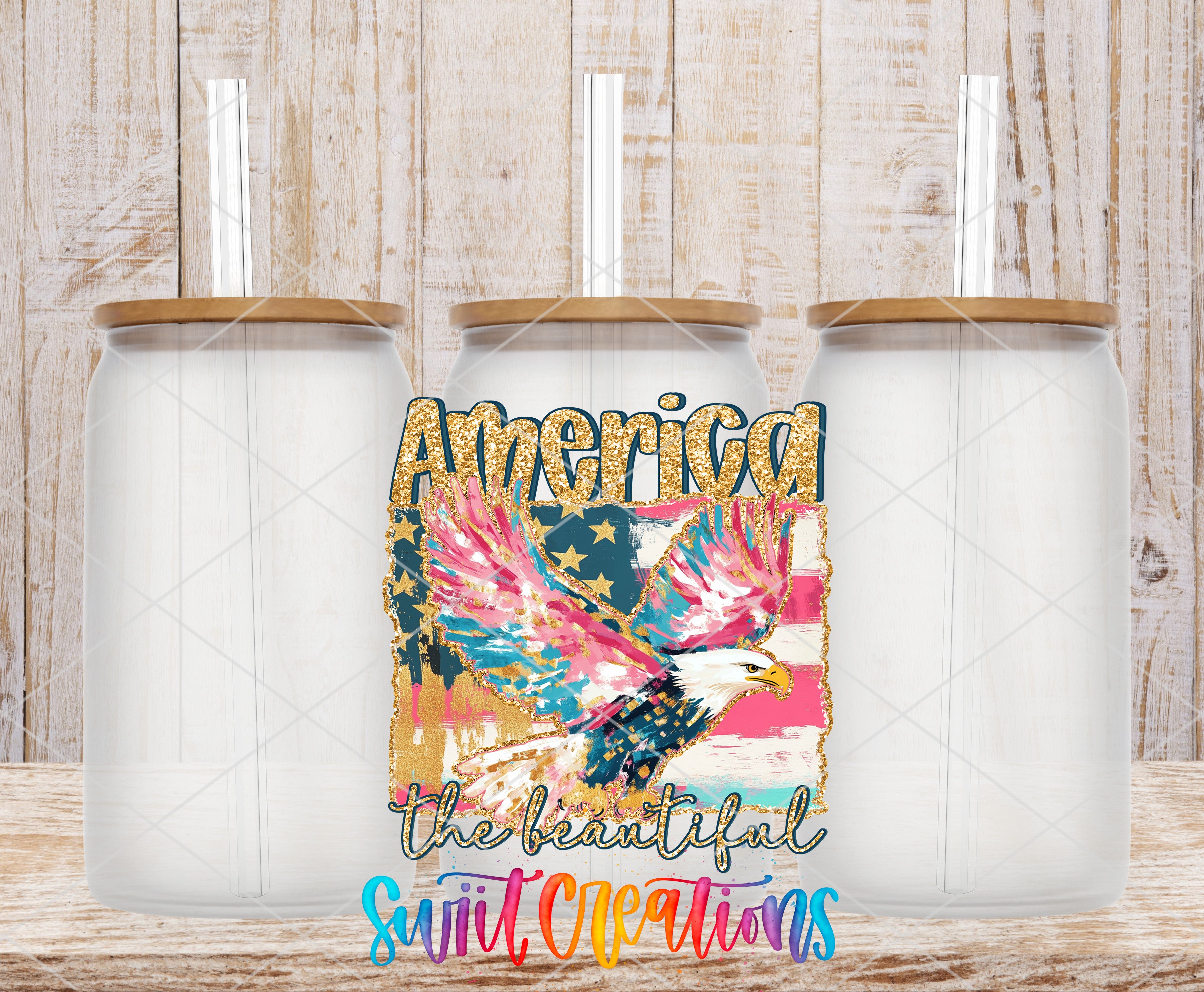 three clear glass jars with lids, arranged in a row against a wooden background. The jars have a colorful design, including a depiction of an eagle and the text "America the beautiful" written in a stylized font.