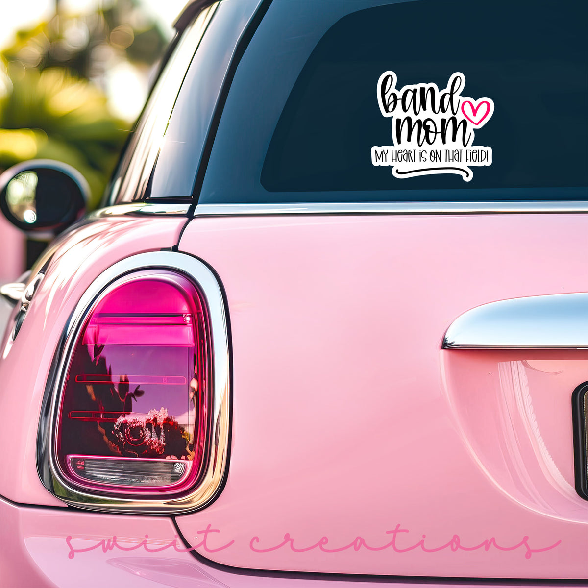 a pink car that has a sticker on it