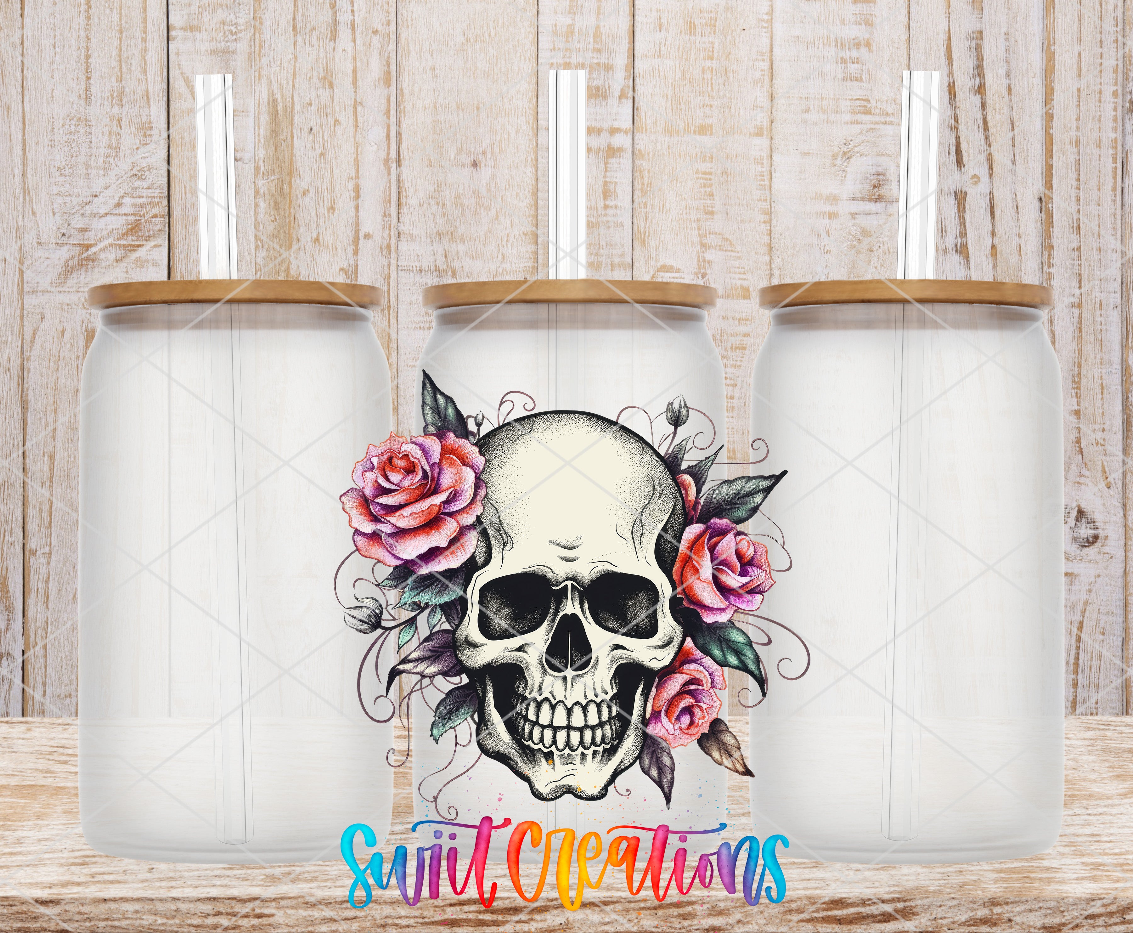 three glass jars with a skull design and floral elements, including roses, against a wooden background.