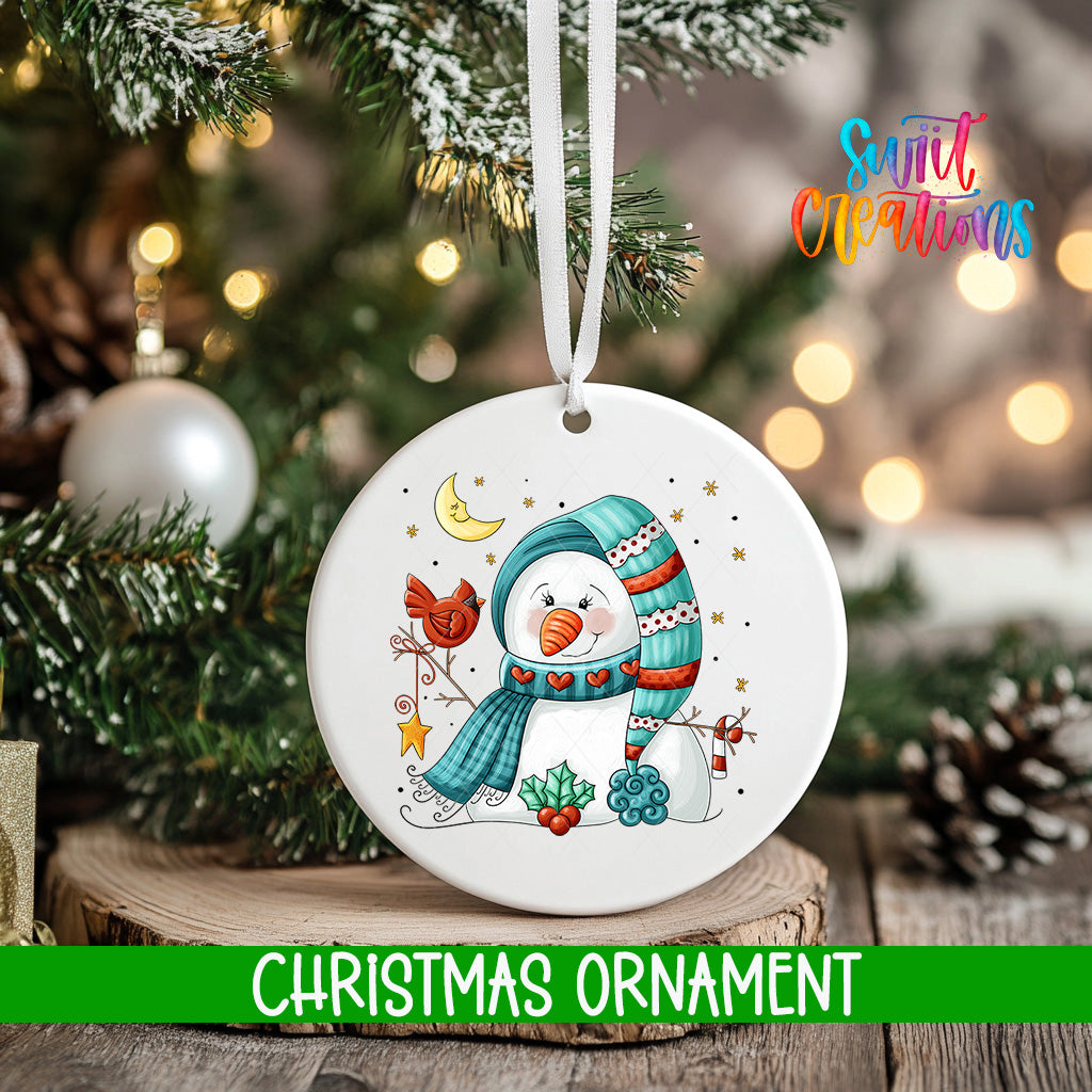 A white Christmas ornament featuring a snowman with a scarf and hat, surrounded by snowflakes and stars, hangs from a tree branch.