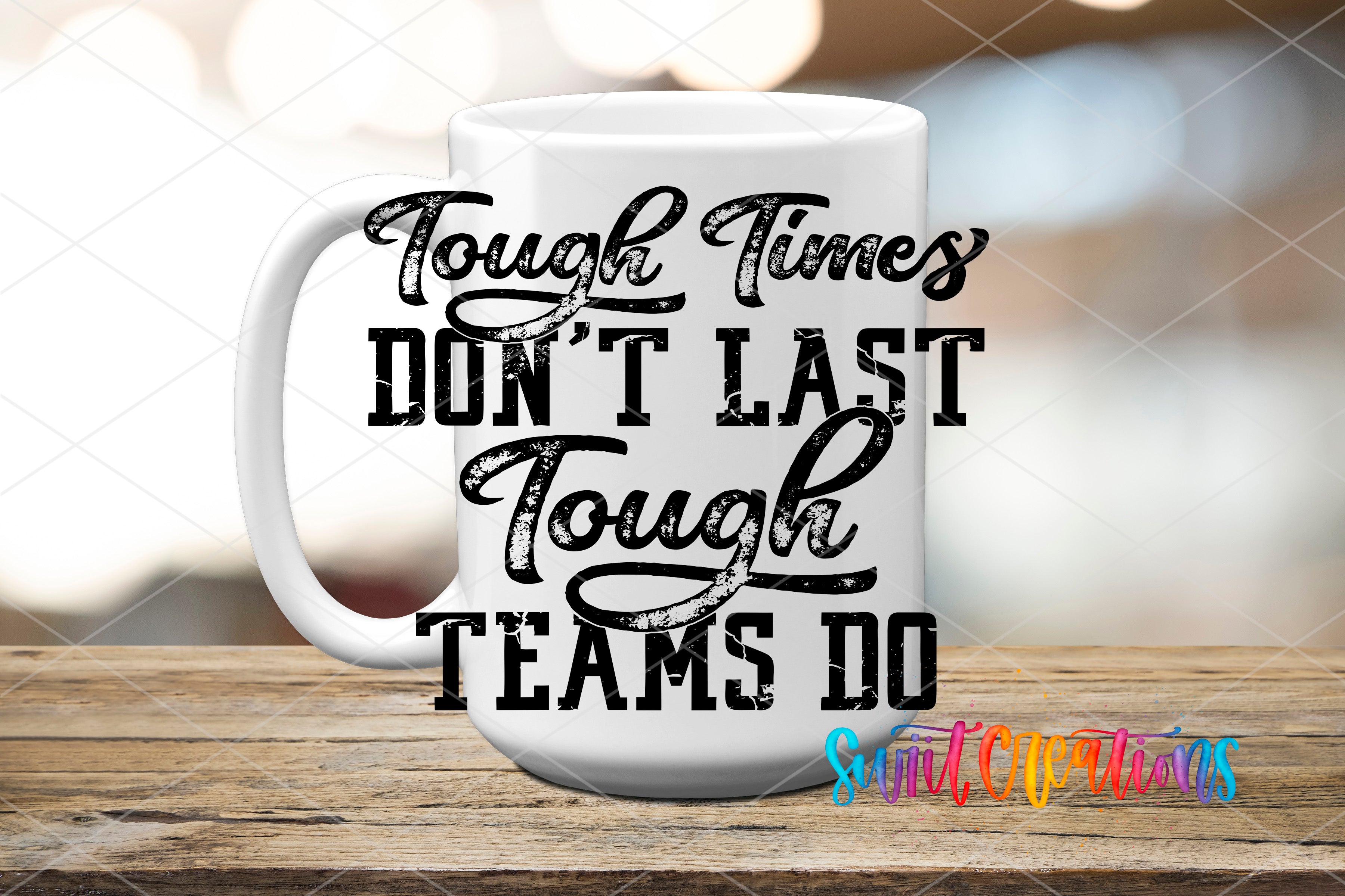 A white mug with the text "Tough Times Don't Last Tough Teams Do" printed on it, placed on a wooden surface.