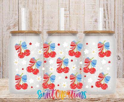 4th of July Cherries UV DTF wrap on three clear glass cans with bamboo lids