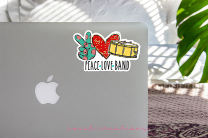 Peace Love Band sticker on the lid of a silver laptop
