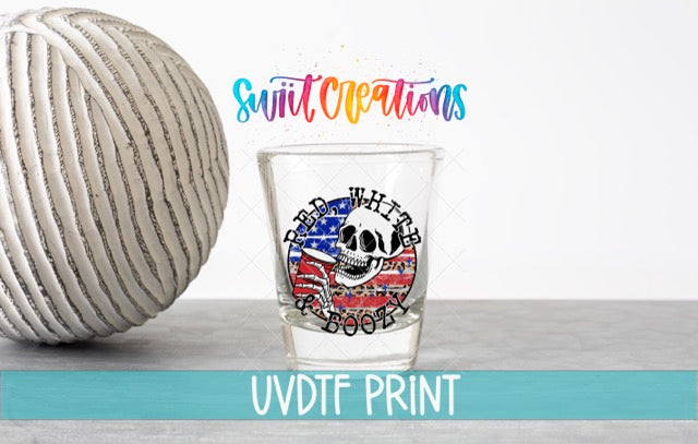 a ball of yarn next to a shot glass