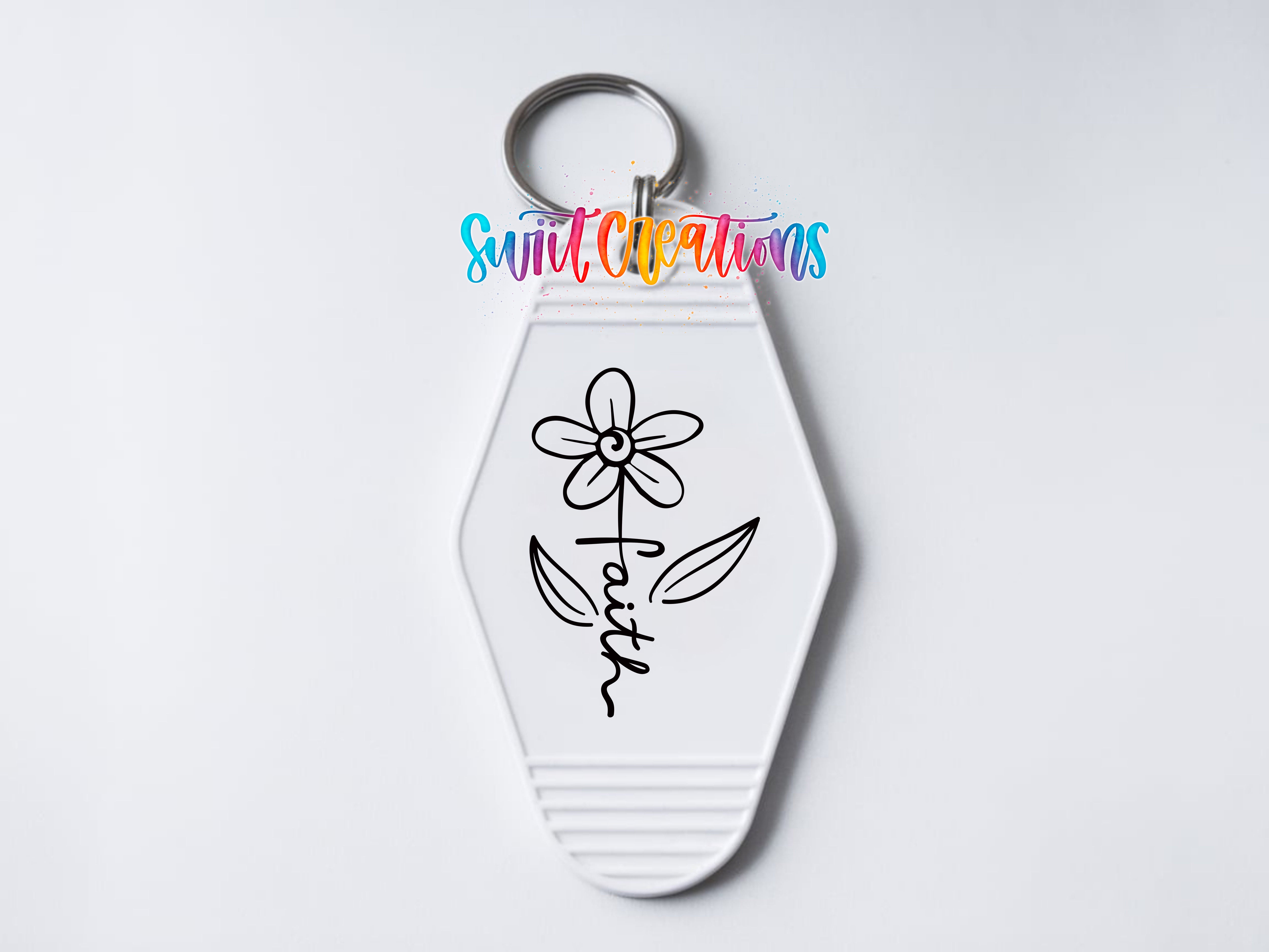 A keychain with a flower design and the word "Faith" written on it.