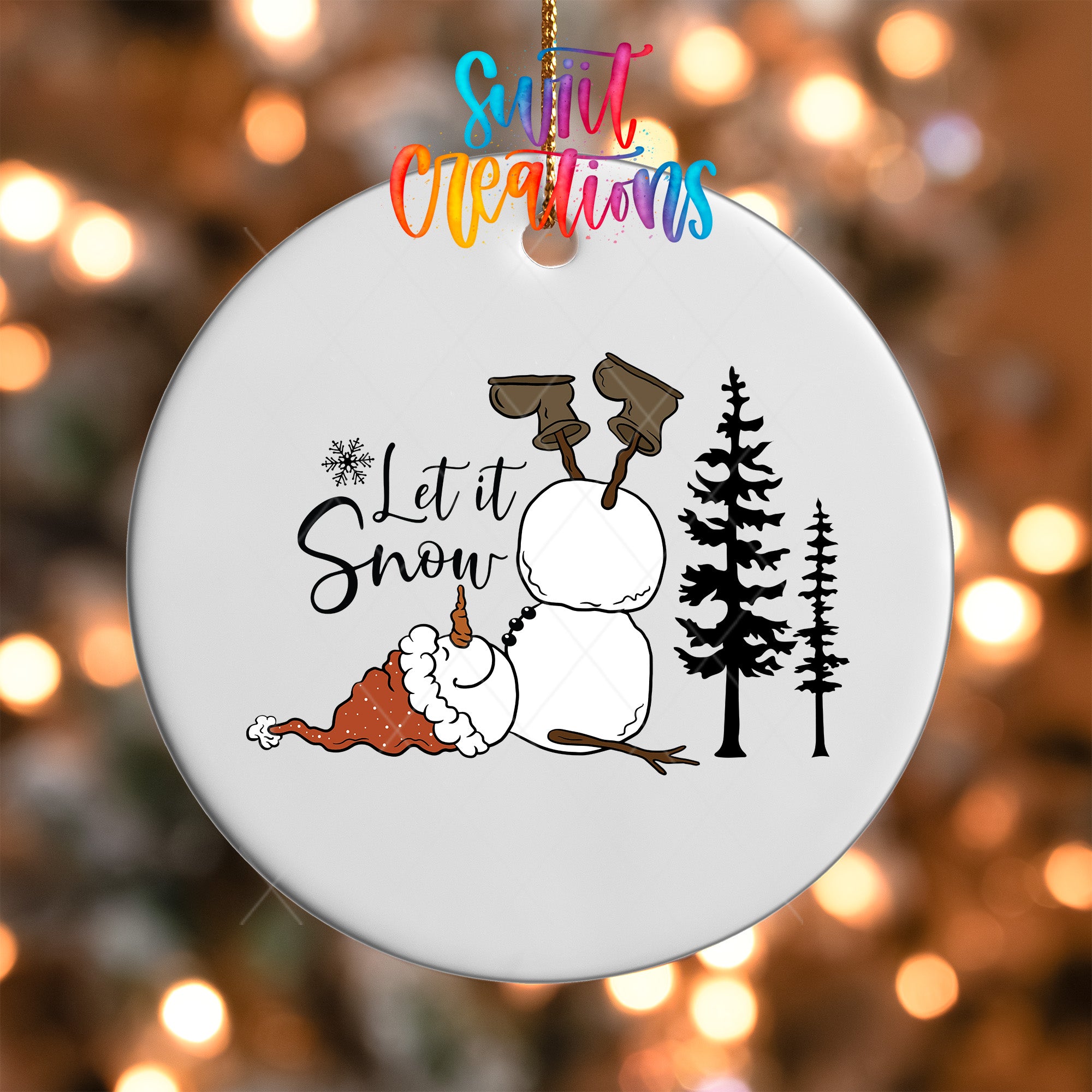 A white ornament with a snowman and trees, along with the text "Let it Snow" written on it.