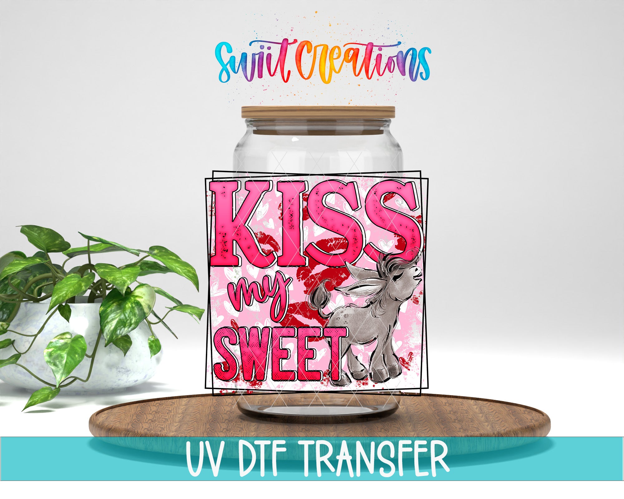 a glass jar with a pink and red design, along with the text "KISS my SWEET" and a small illustration of a person. The jar is placed on a wooden surface, and there is a potted plant in the background.