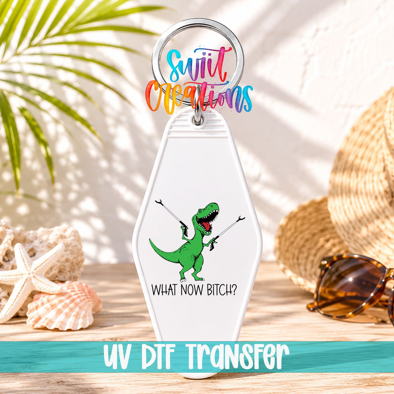 A keychain with a dinosaur graphic and the text "WHAT NOW BITCH?" printed on it, along with a colorful ring and the text "UV Dtf Transfer".