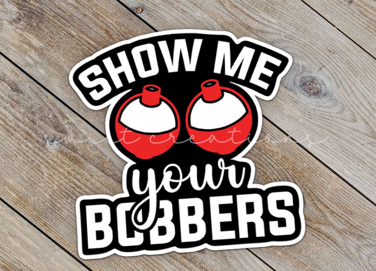 Close-up of the Show Me Your Bobbers sticker on rustic wood