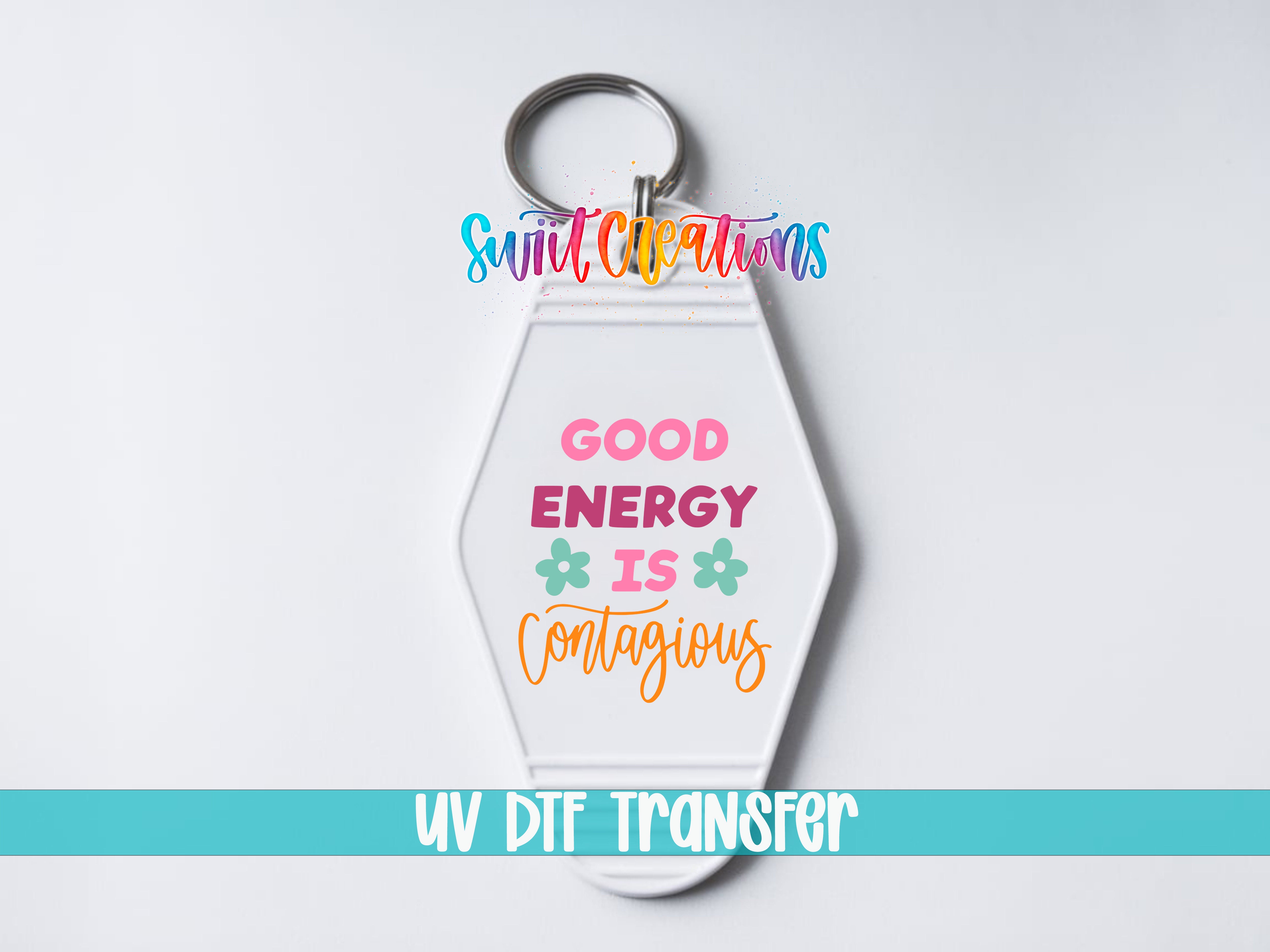 A keychain with a message that says "GOOD ENERGY IS CONTAGIOUS" in a colorful, stylized font.