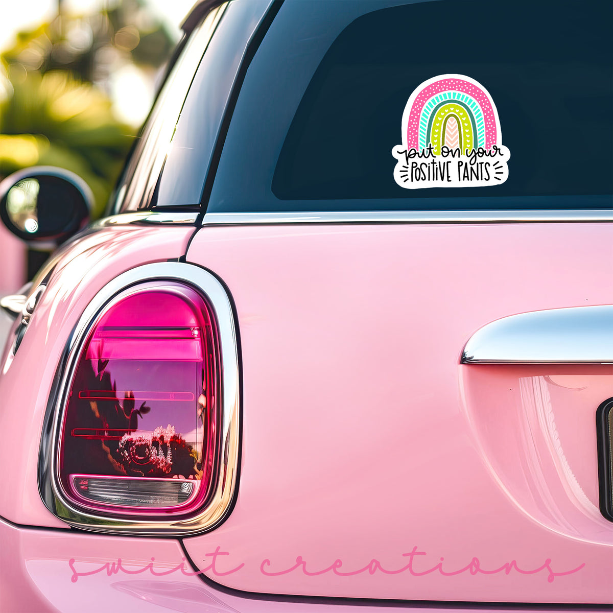 a pink car with a rainbow sticker on it