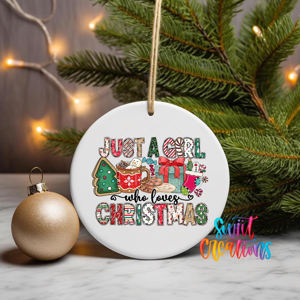 A white ceramic ornament with a festive design hangs on a Christmas tree, surrounded by twinkling lights and greenery.