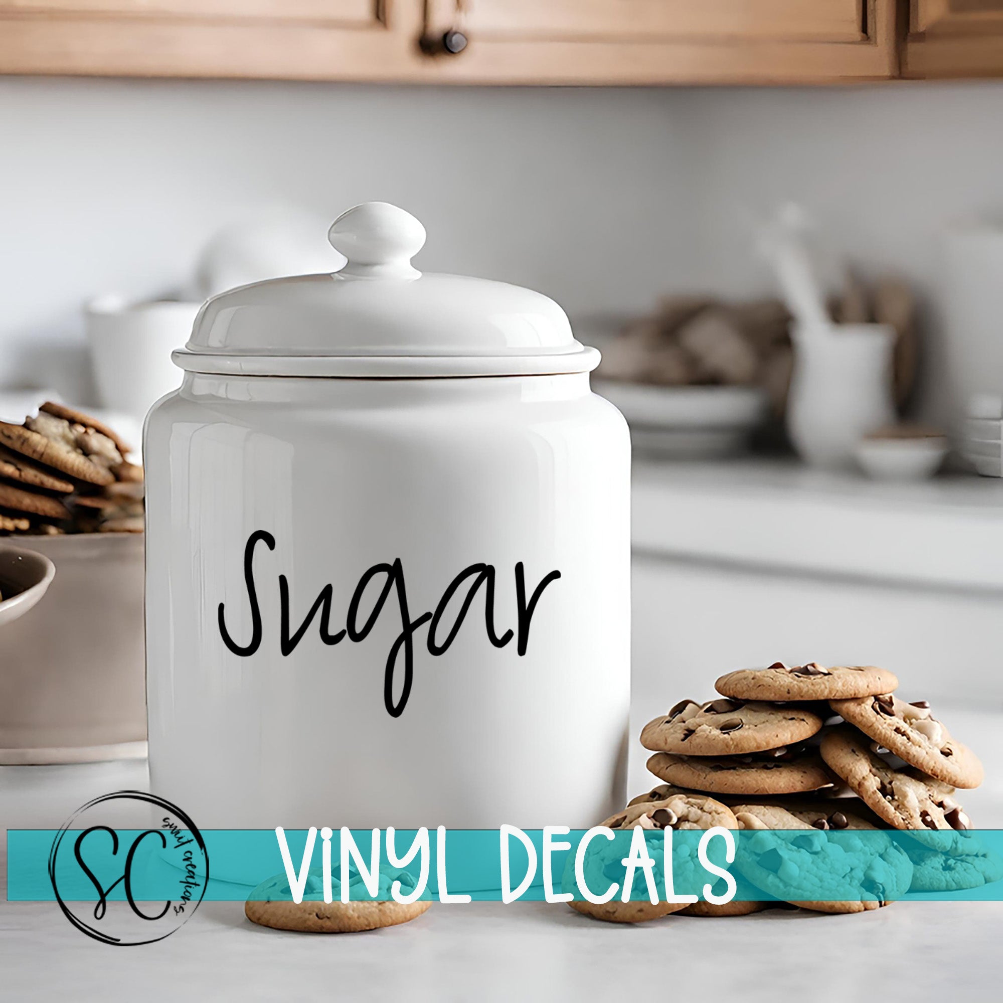A white ceramic sugar jar with the word "Sugar" written on it, placed on a kitchen counter next to a stack of chocolate chip cookies.
