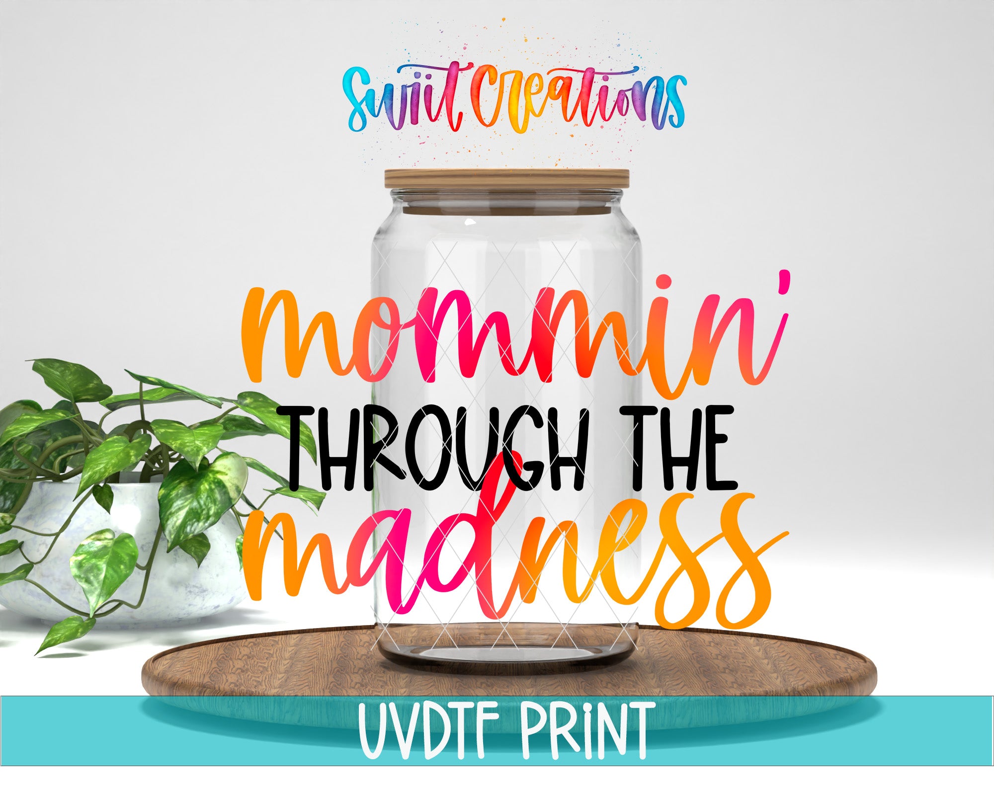 a glass jar with a wooden lid, placed on a wooden board, and there is a plant in a white pot next to it. The text overlay on the image says "swift creations mommin' through the madness UVDF PRINT".