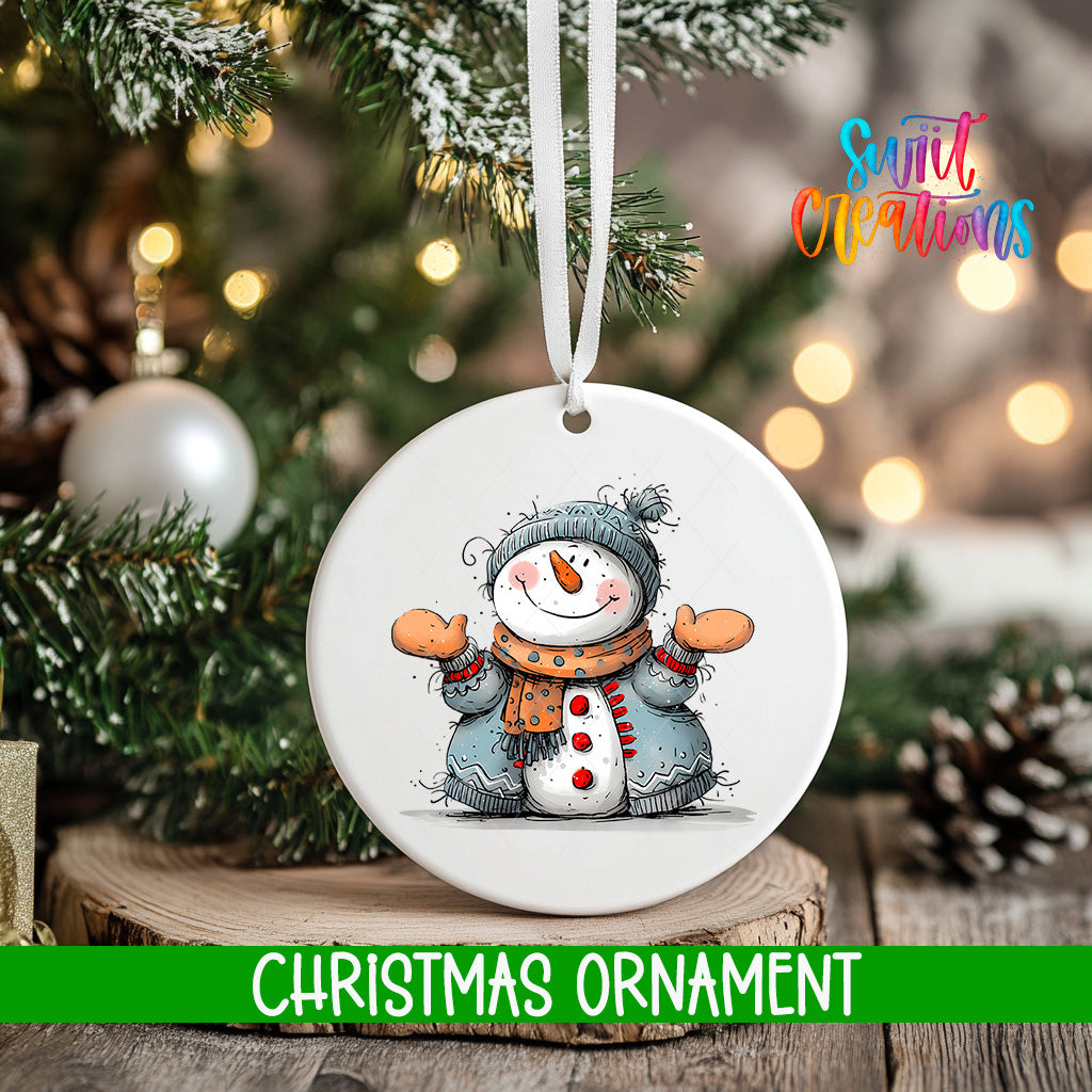 A white Christmas ornament featuring a snowman is hanging from a tree branch, with a blurred background of lights and greenery.