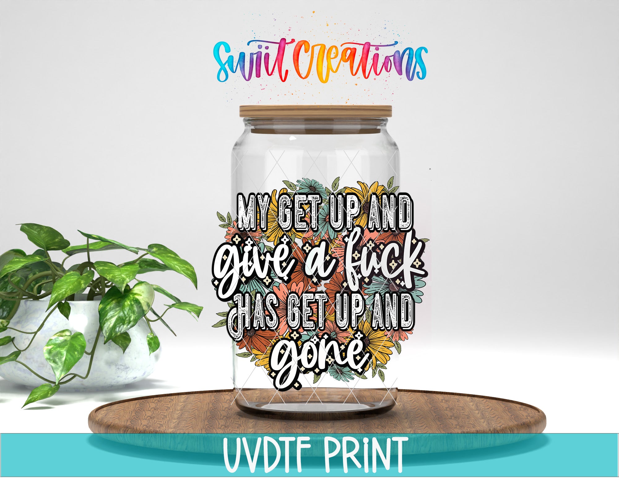 a glass jar with a colorful floral design and text on it, placed on a wooden surface.