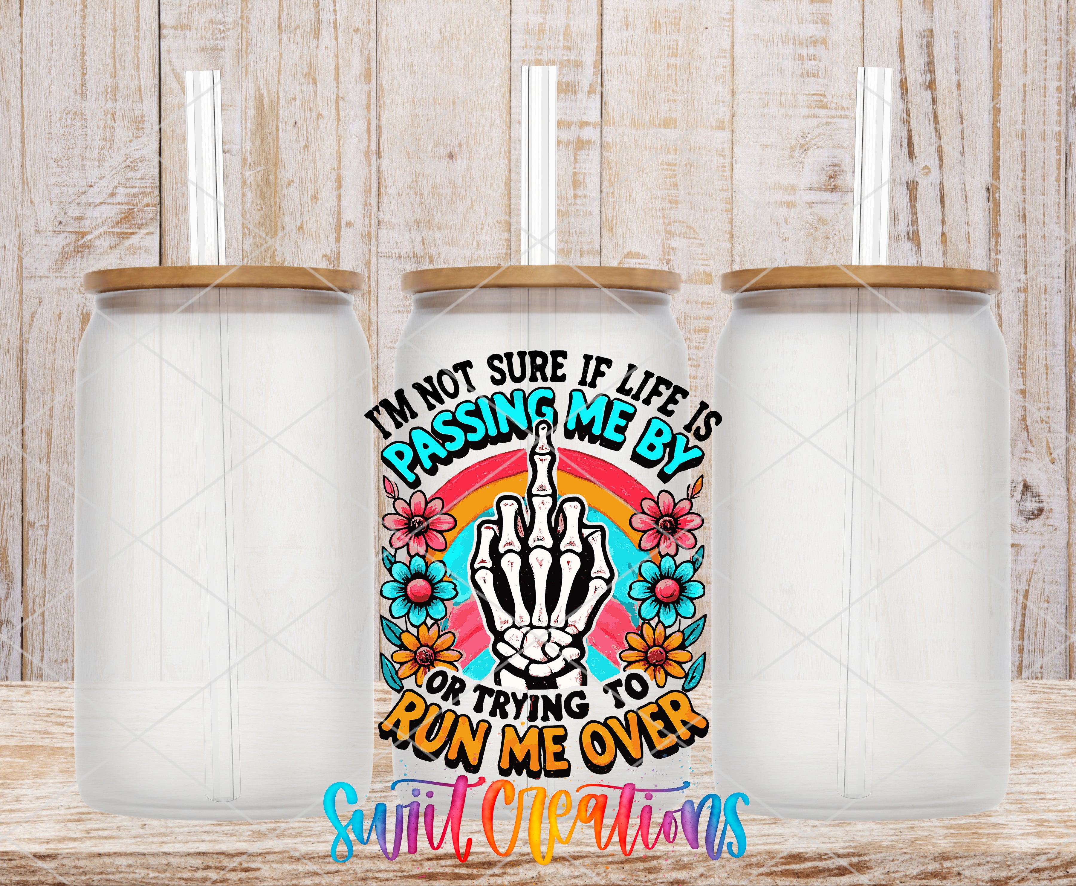 three clear glass jars with lids, arranged in a row against a wooden background. In the center of the image, there is a colorful graphic design with a skeleton hand making a peace sign, surrounded by flowers and text.