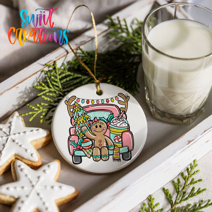 a Christmas ornament with a gingerbread man and a truck, along with a glass of milk and some cookies on a white tray.